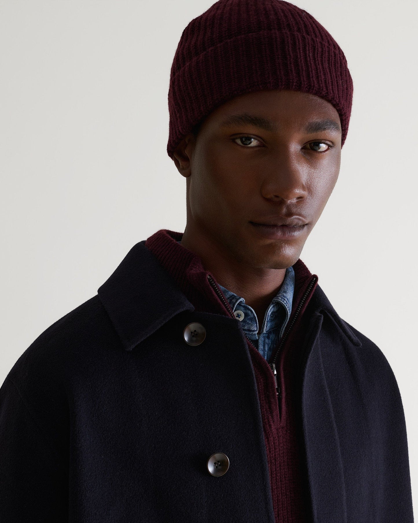 Image 1 of 3 showing man wearing Rise & Fall's Cashmere Merino Ribbed Knit Beanie in oxblood.