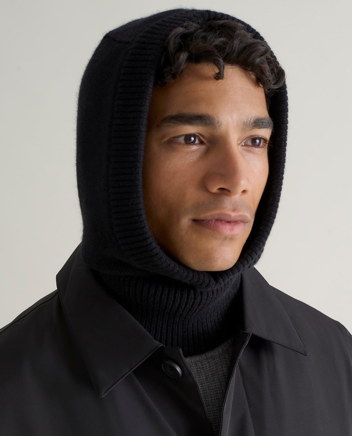 Image 1 of 4 showing man wearing Rise & Fall's black Cashmere Merino Knitted Hood.