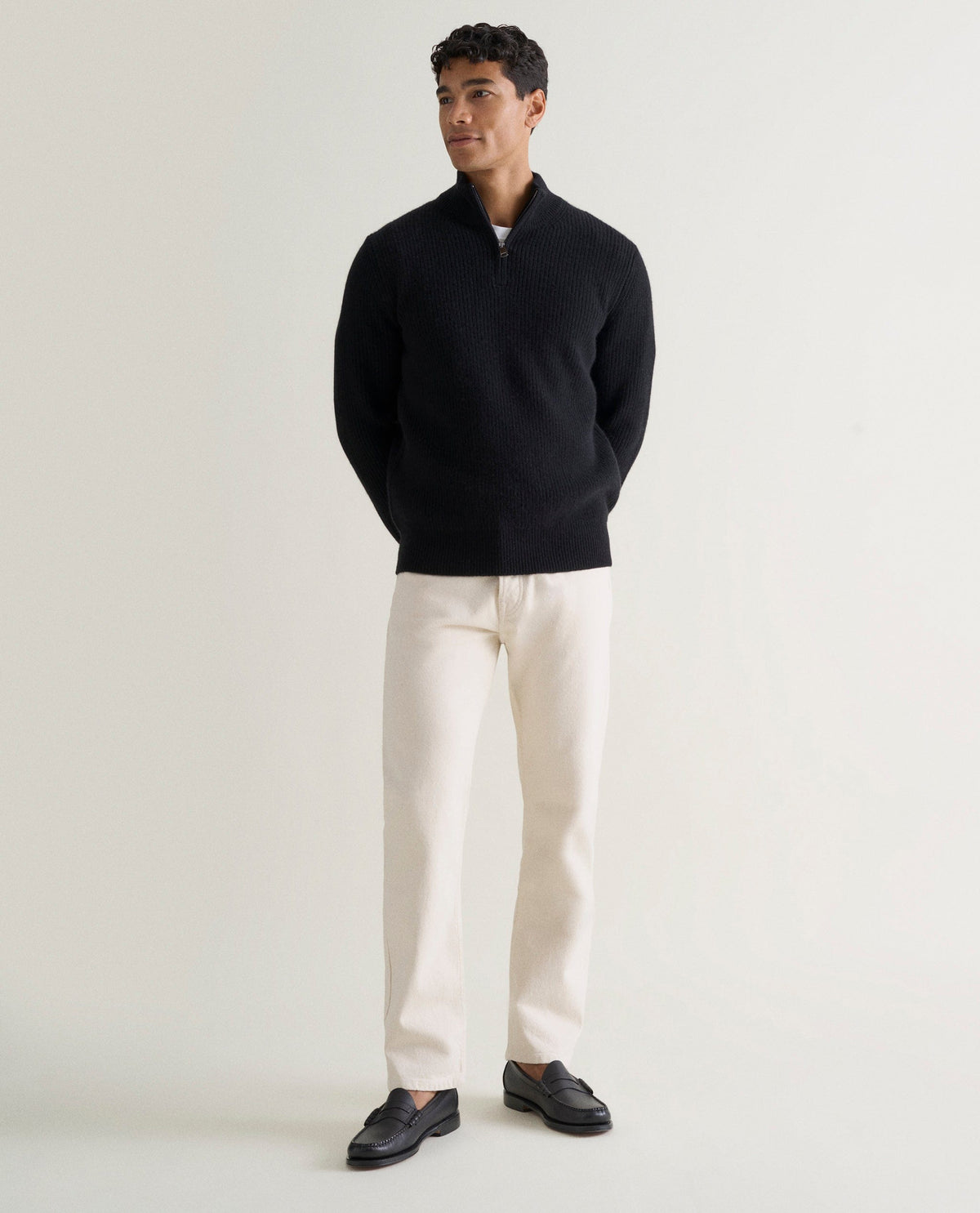 Image 1 of 6 showing man wearing Rise & Fall's Cashmere Merino Fishermans Rib 1/4 Zip Jumper in black.