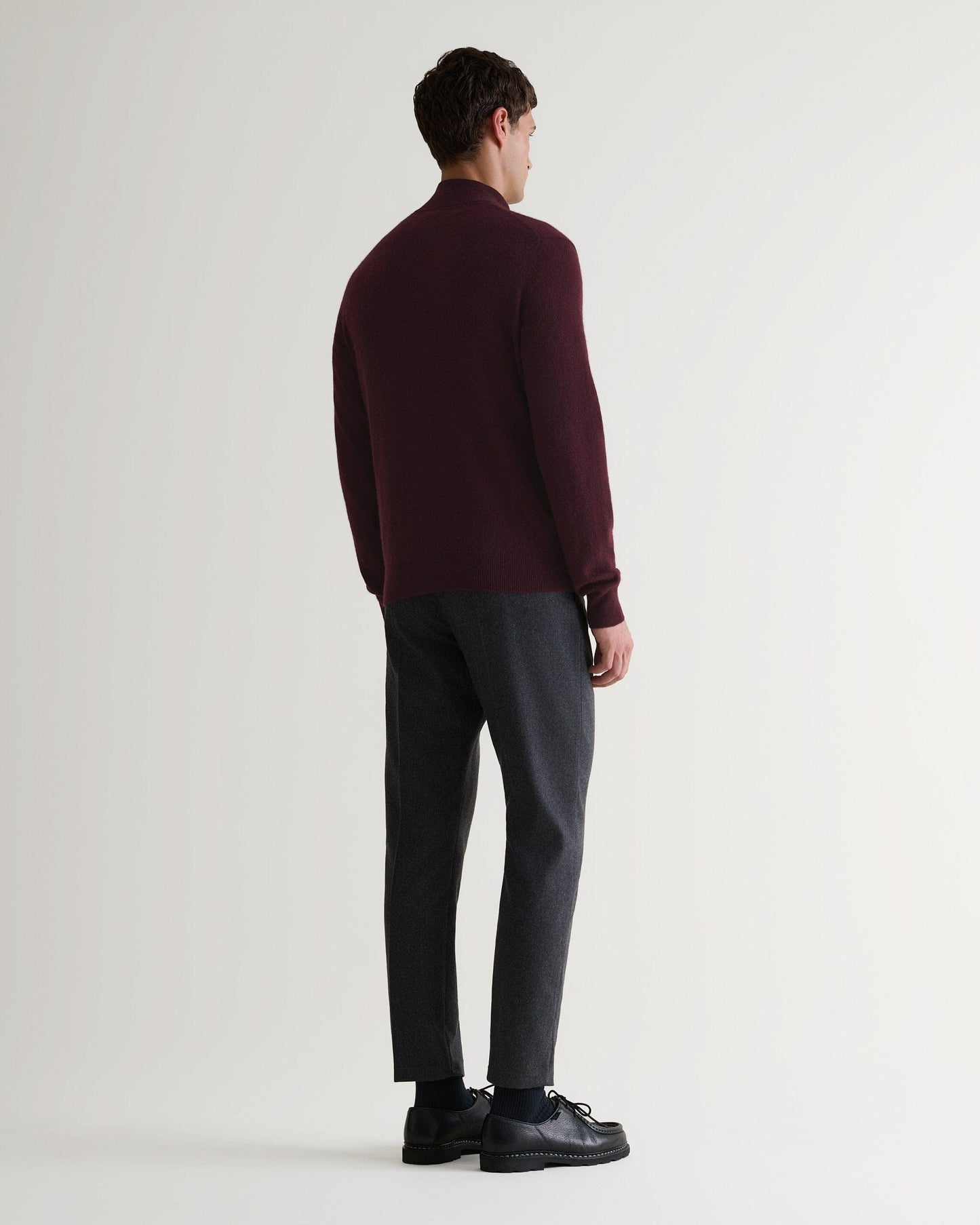 Image 2 of 6 showing man wearing Rise & Fall's fine cashmere 1/4 zip jumper, oxblood, back view.