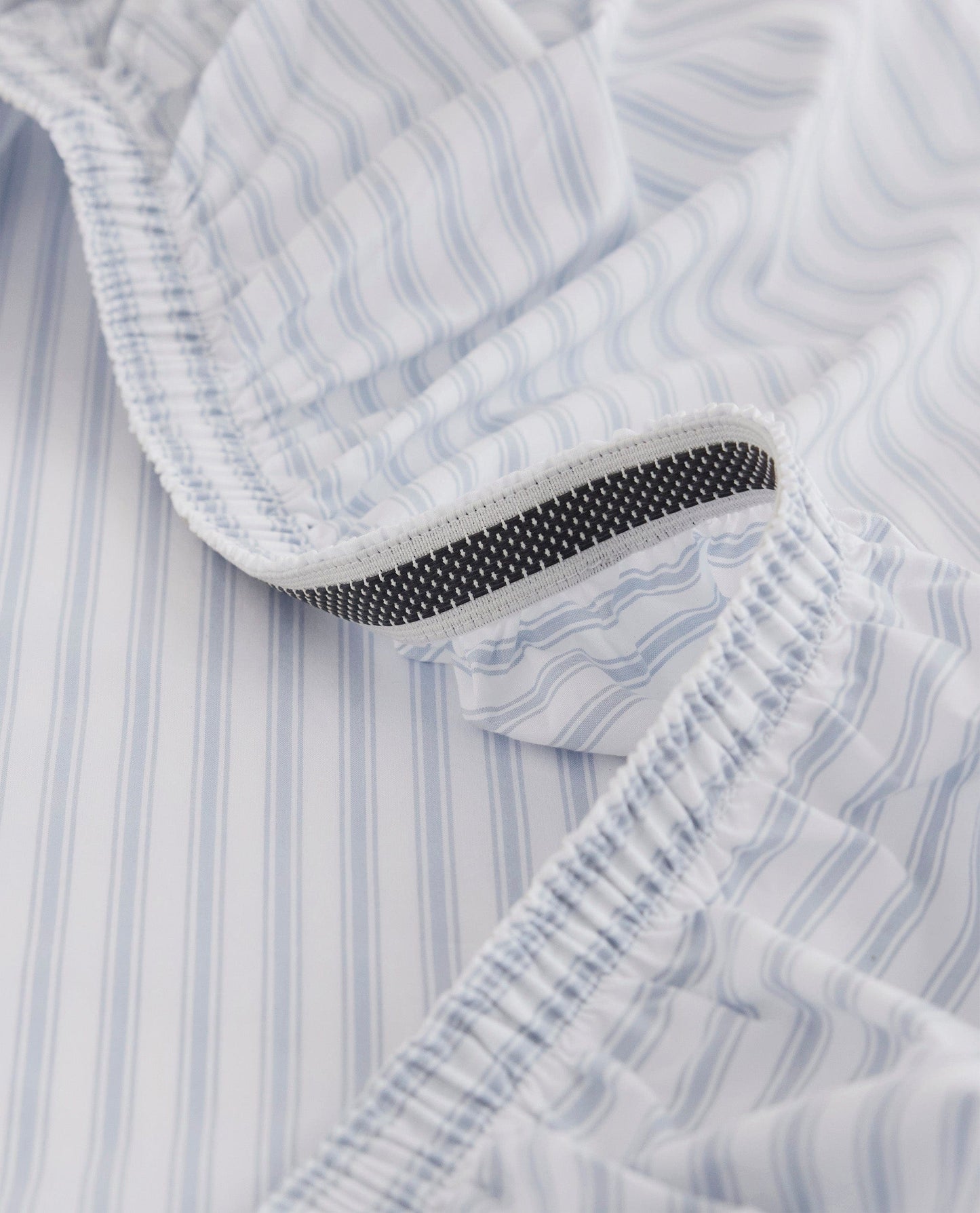 Image 2 of 6 showing Rise & Fall's Crisp & Cool organic cotton fitted bed sheet in blue stripe ticking.