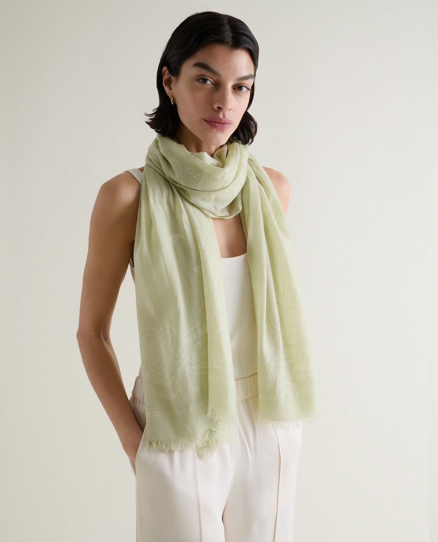 Image 3 of 3 showing woman wearing Rise & Fall's Lightweight Cashmere Scarf With Ampersand Print in lichen green.