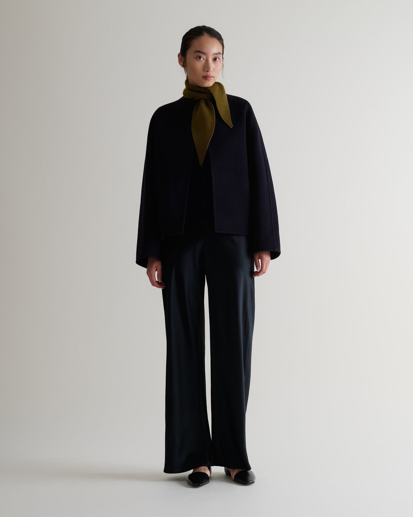 Image 3 of 3 showing Rise & Fall's finest cashmere ribbed micro bandana in olive with black trousers and jacket.