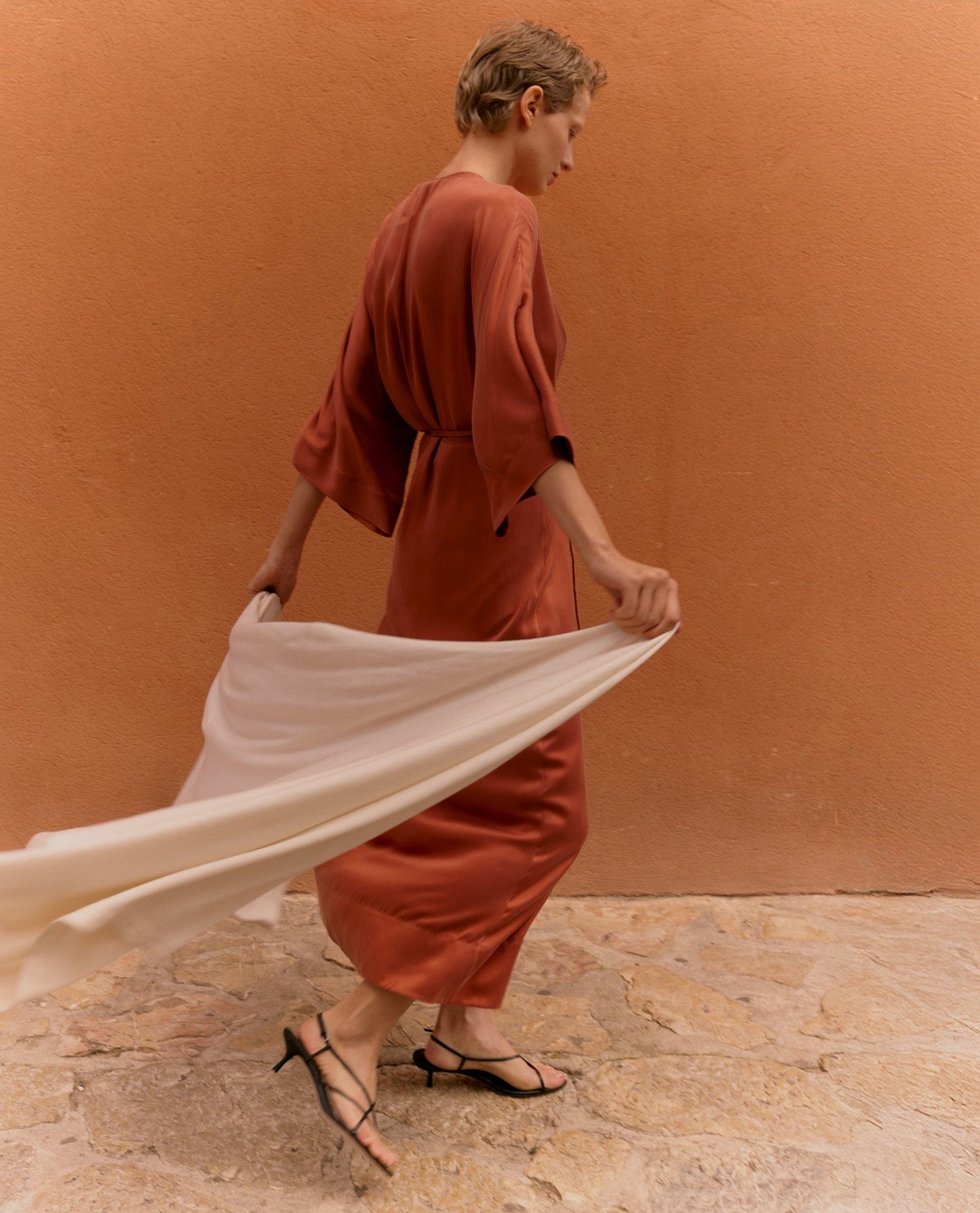 Image 3 of 4 showing woman holding Rise & Fall's buttermilk oversized cashmere scarf.