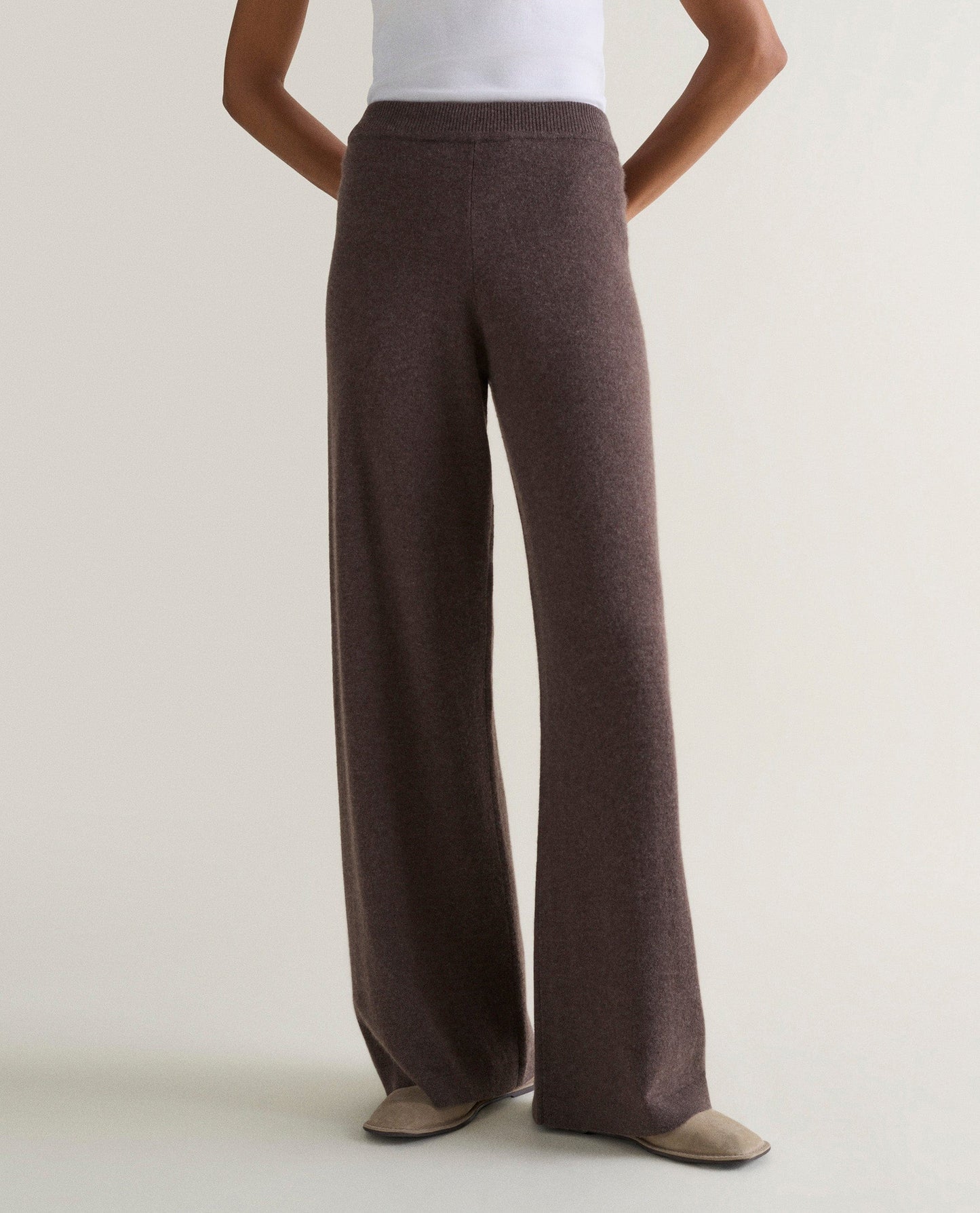 Image 3 of 4 showing woman wearing Rise & Fall's chocolate brown fine cashmere wide-leg trousers with white top.
