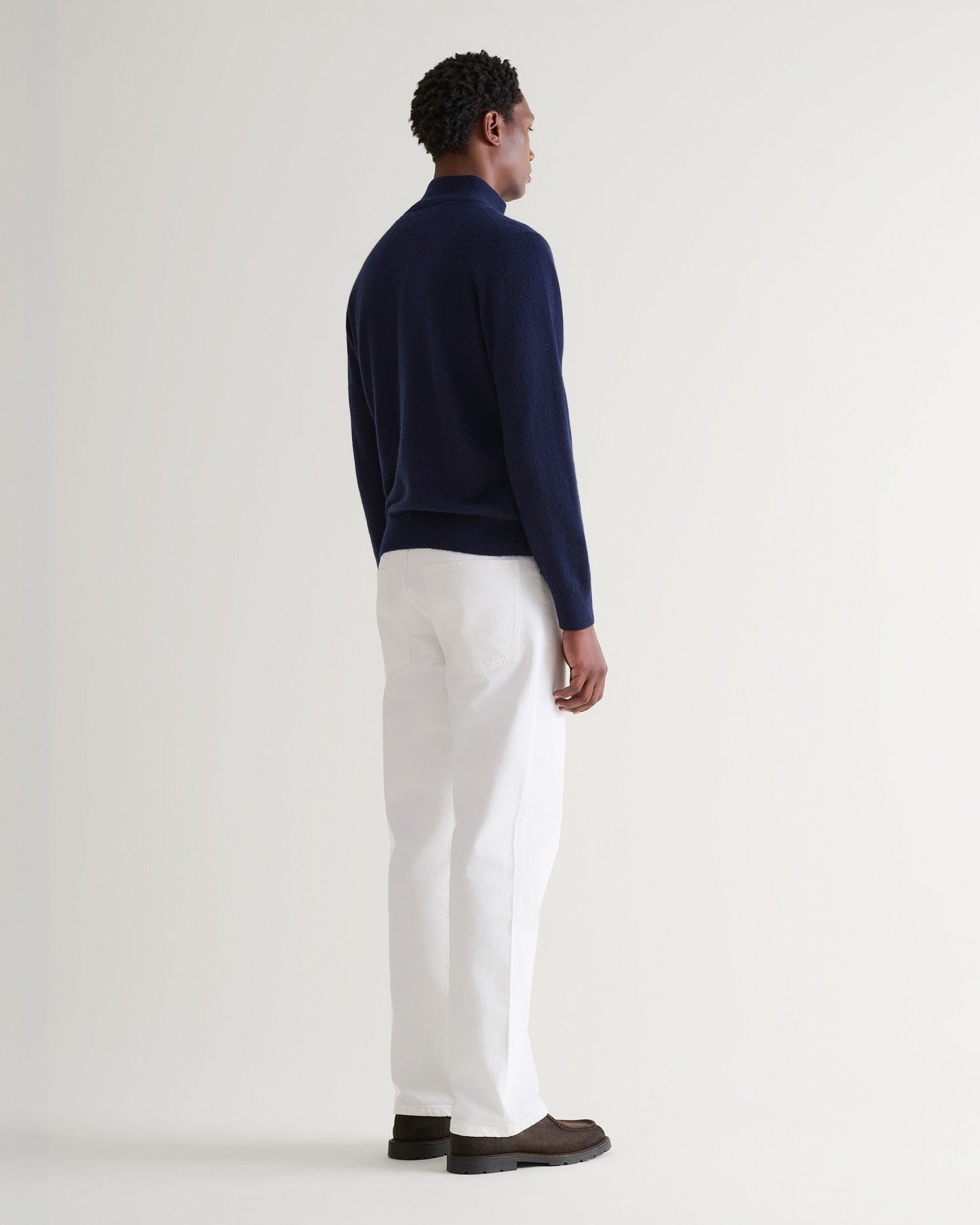Image 3 of 5 showing man wearing Rise & Fall's fine cashmere 1/4 zip jumper, navy, back view.