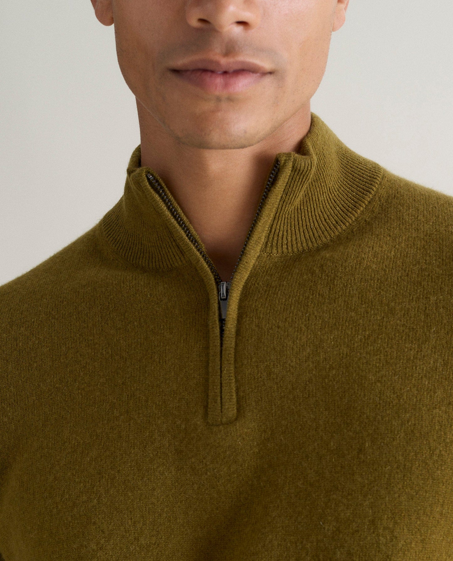 Image 4 of 5 showing man wearing Rise & Fall's fine cashmere 1/4 zip jumper, olive, close up.