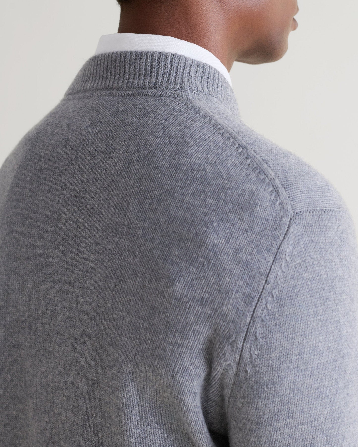 Image 5 of 5 showing close up of man wearing Rise & Fall's finest cashmere mid-weight crew neck jumper in grey with white shirt, back view.