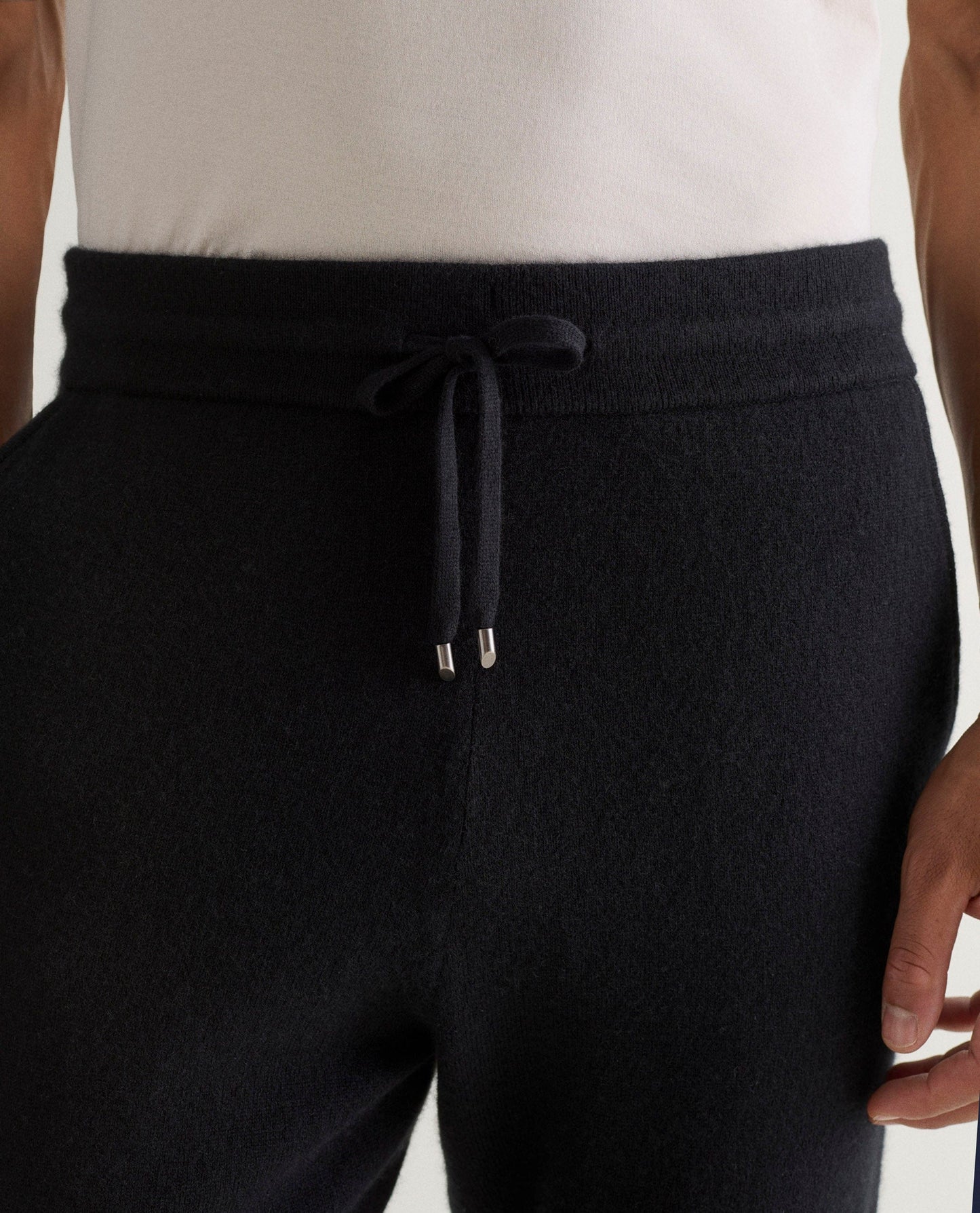Image 5 of 5 showing man wearing Rise & Fall's fine cashmere jogger, black, close up.