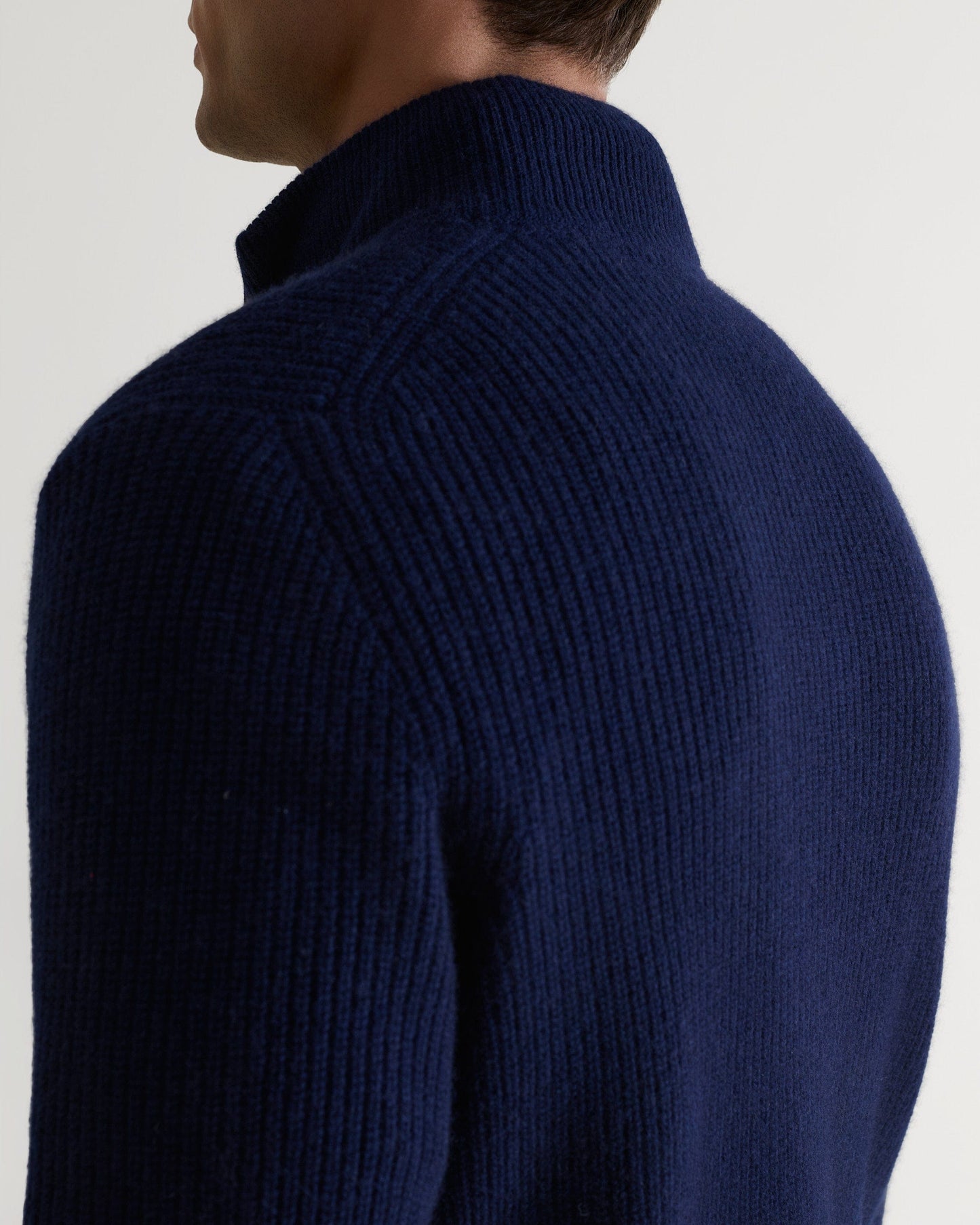 Image 5 of 5 showing close up of man wearing Rise & Fall's Cashmere Merino Fishermans Rib 1/4 Zip Jumper in navy.