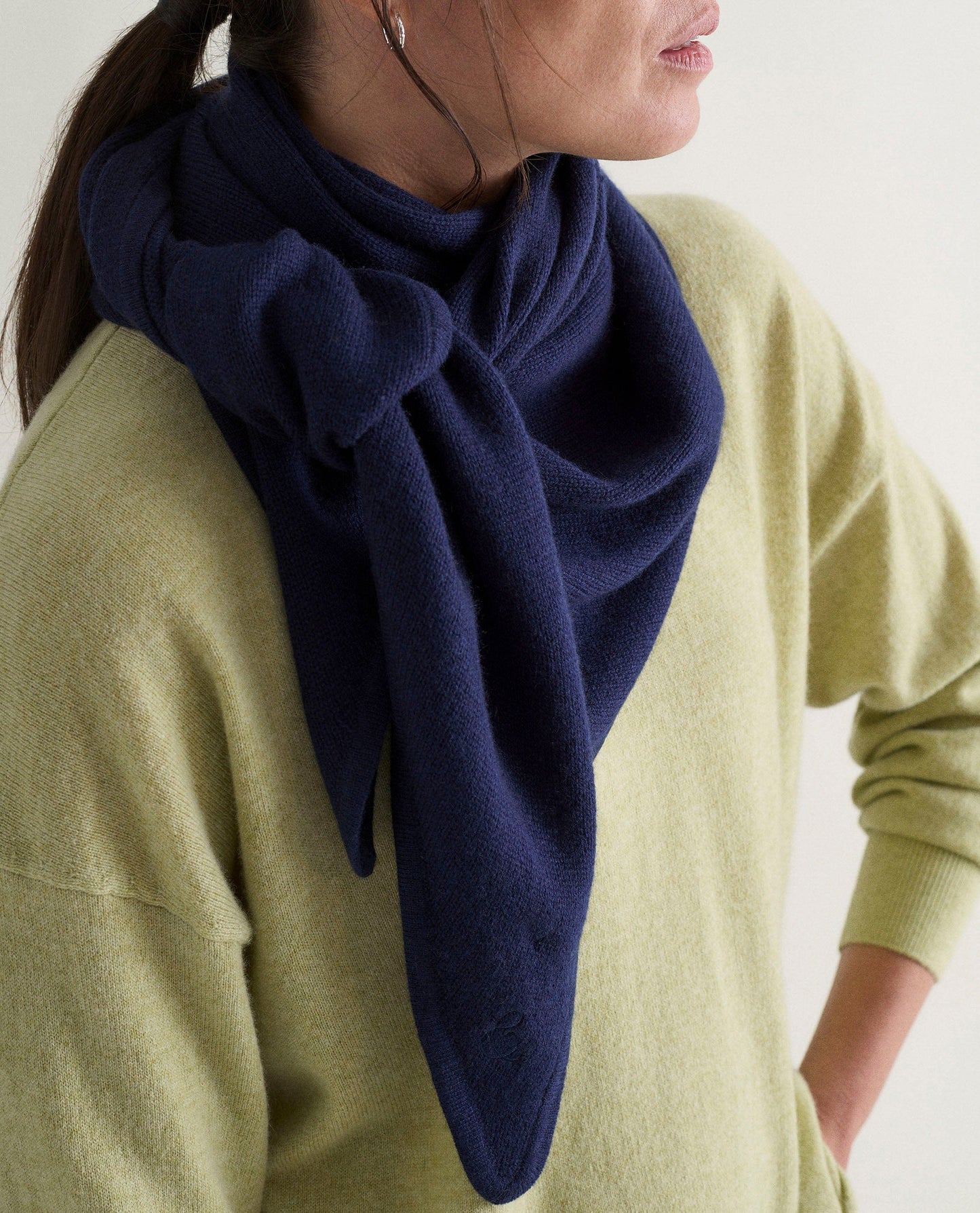 Image 5 of 5 showing woman wearing Rise & Fall's lichen green fine cashmere sweatshirt with navy cashmere bandana.