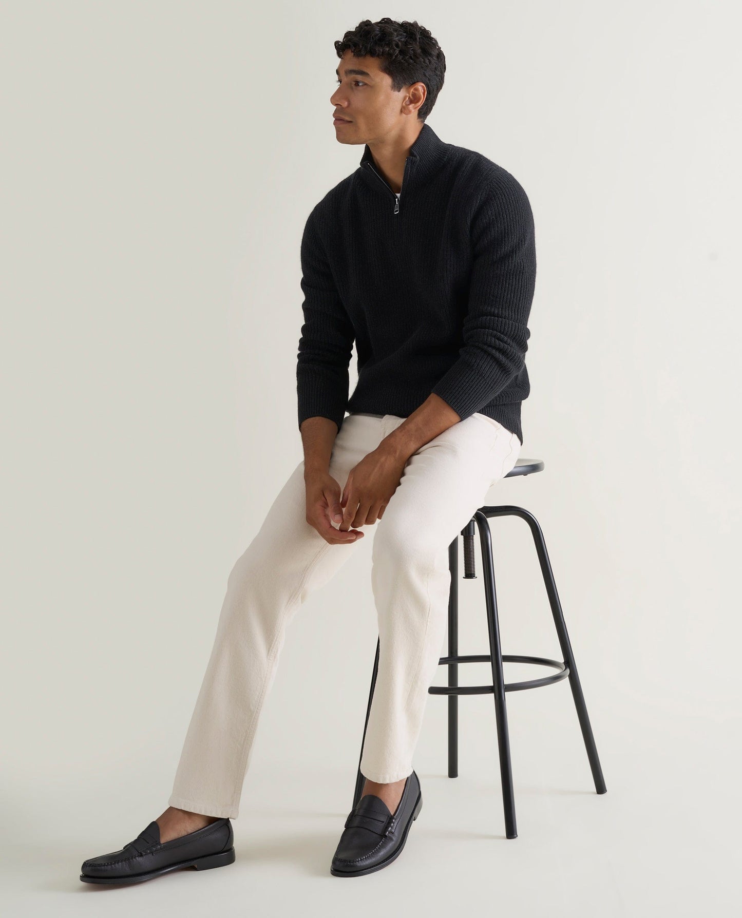 Image 5 of 6 showing man wearing Rise & Fall's Cashmere Merino Fishermans Rib 1/4 Zip Jumper in black.