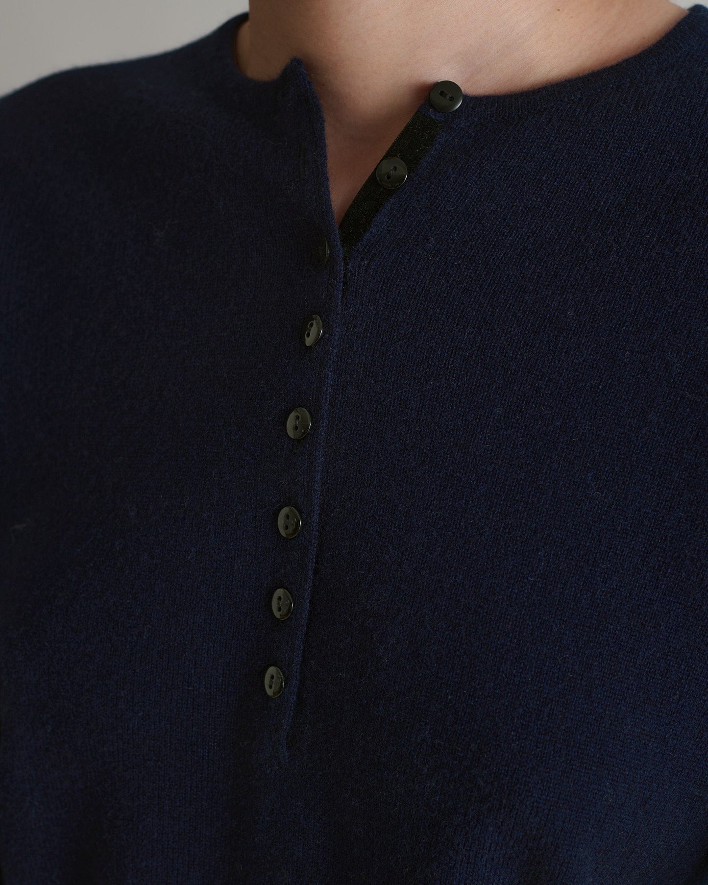 Image 5 of 6 showing close up of Rise & Fall's indigo cashmere merino henley jumper.
