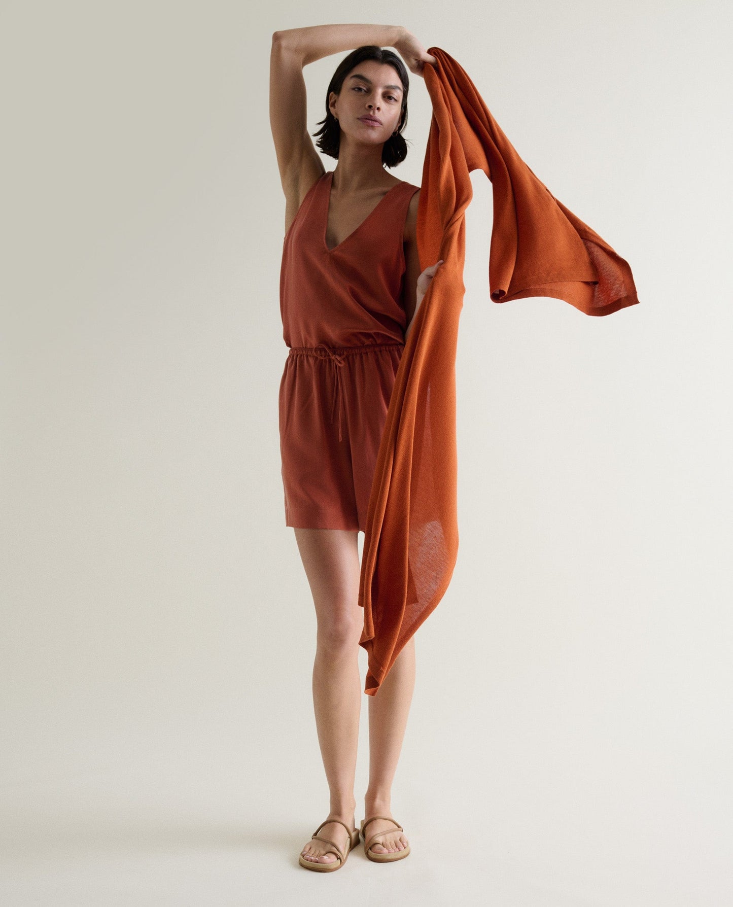 Image 6 of 6 showing woman drapping with Rise & Fall's rust coloured oversized cashmere scarf over shoulders.