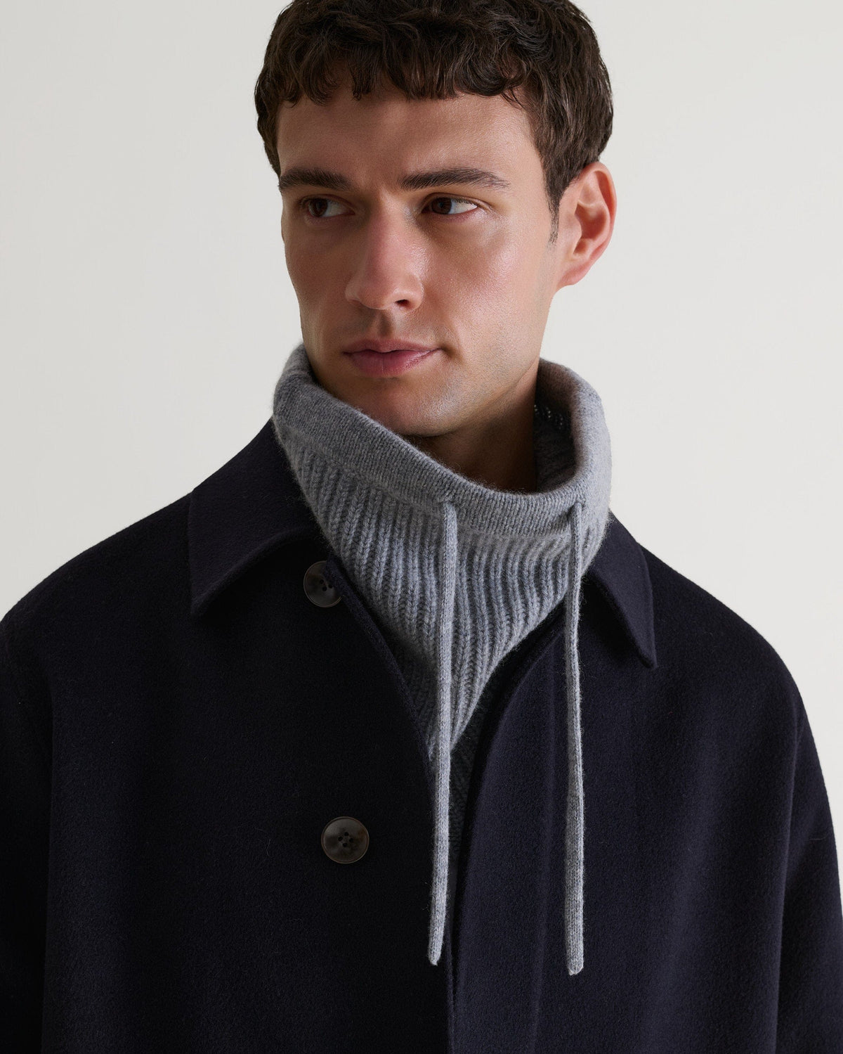 Man wearing grey cashmere merino drawstring snood with navy coat