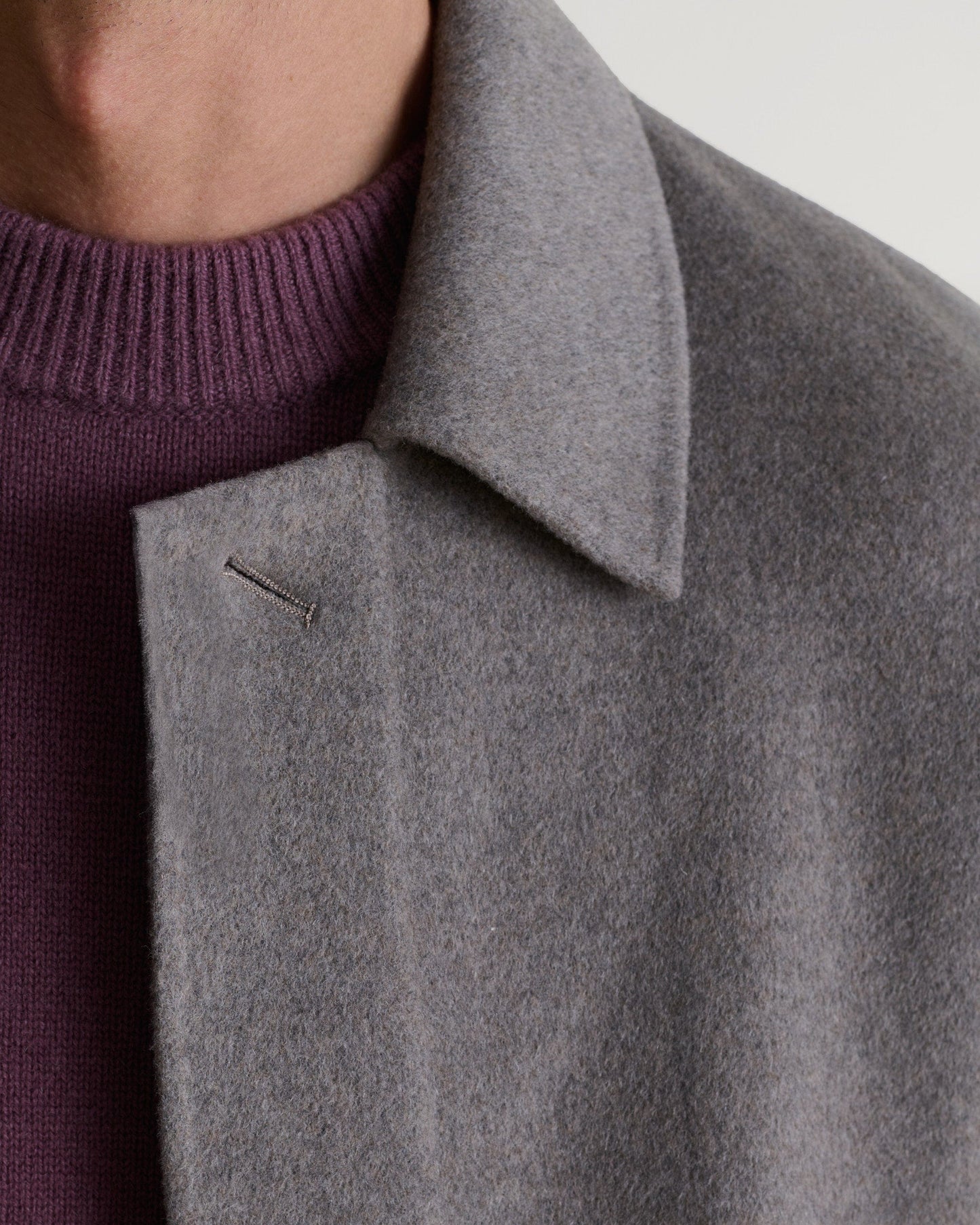 Rise & Fall's fawn coloured cashmere merino double-faced wool coat. Matched with burgundy jumper. Close up of neckline.
