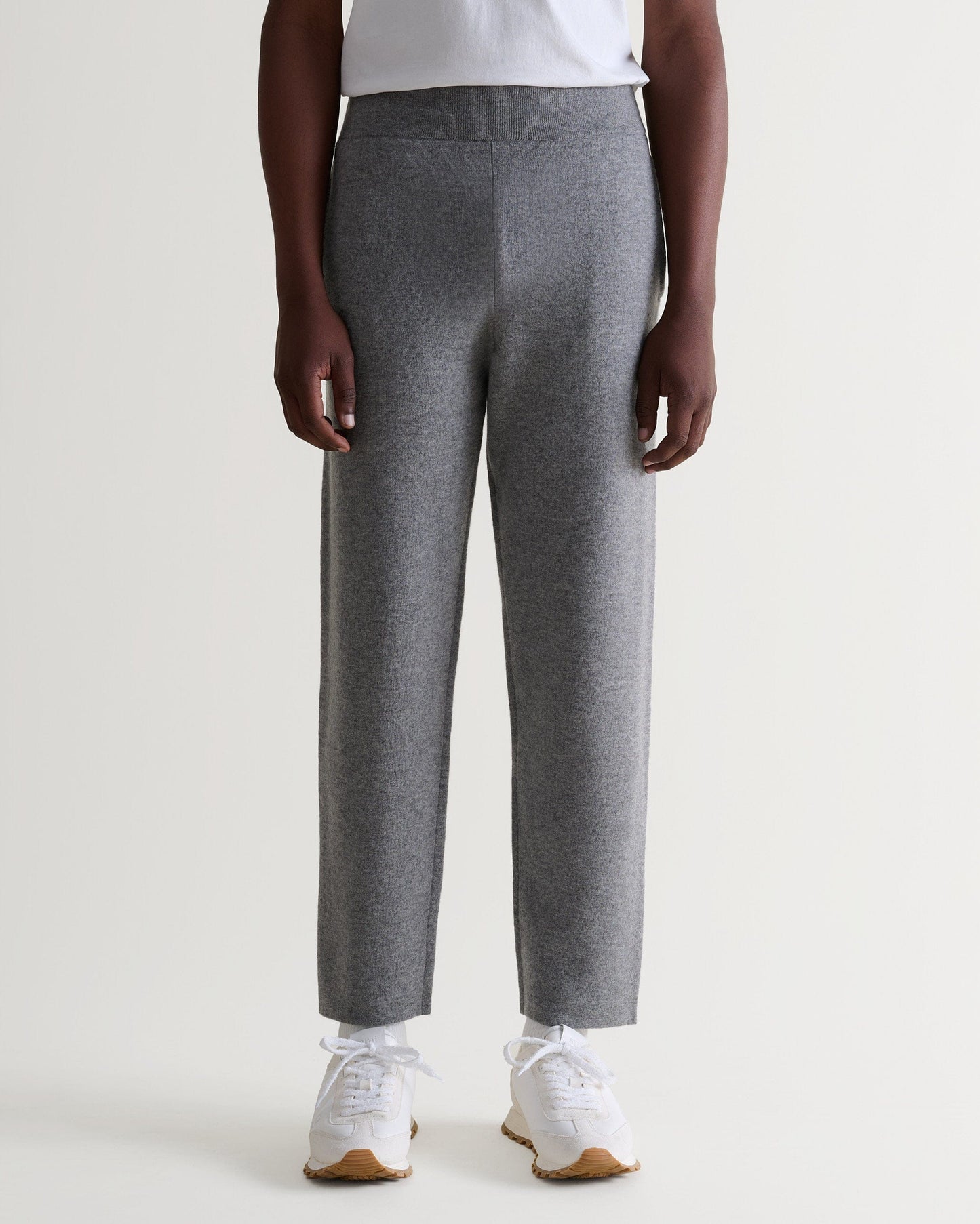 Close up of Rise & Fall's grey cashmere merino double-faced joggers with white T-shirt and trainers.