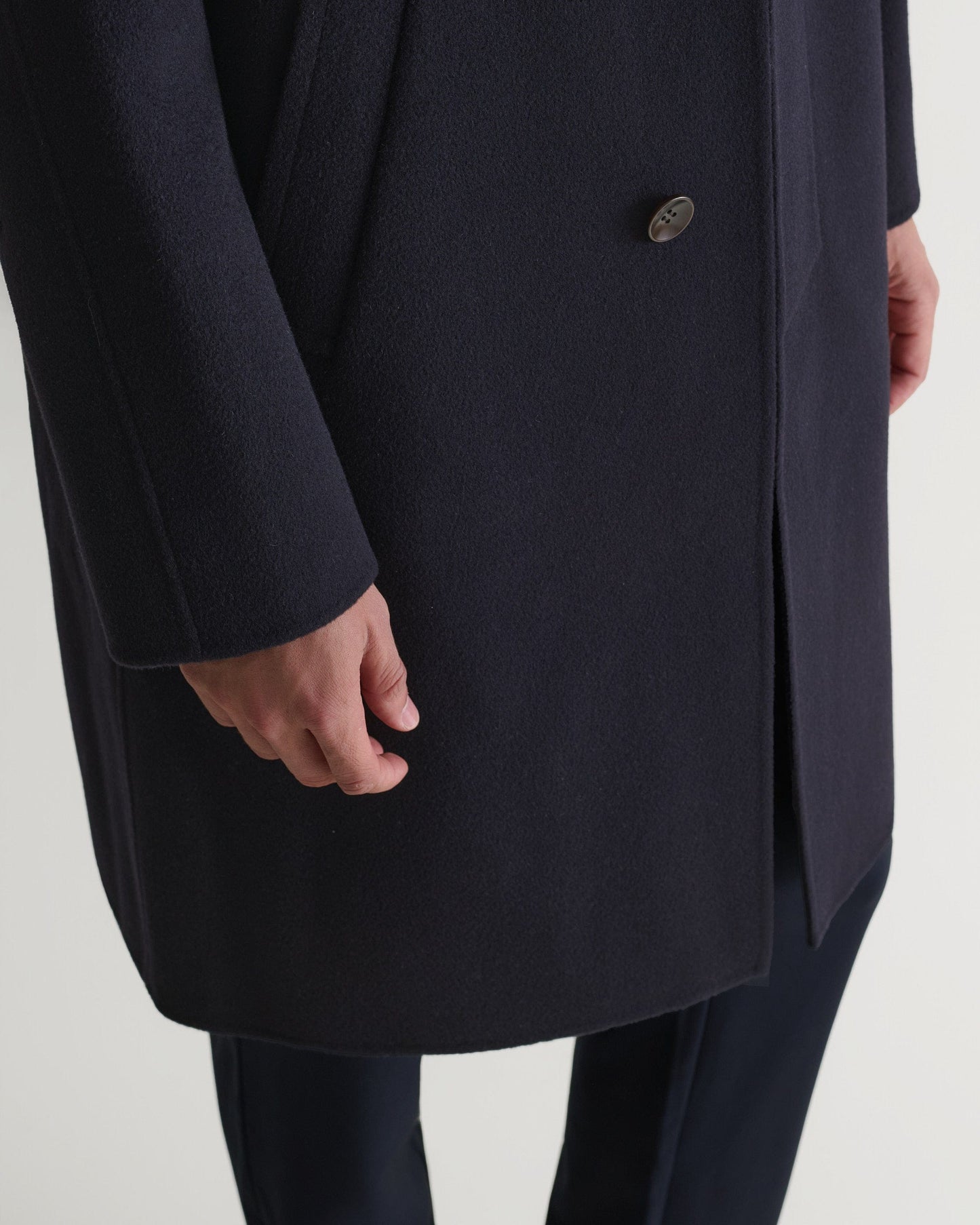 Rise & Fall's navy cashmere merino wool double-faced coat. Close up of bottom front edge.