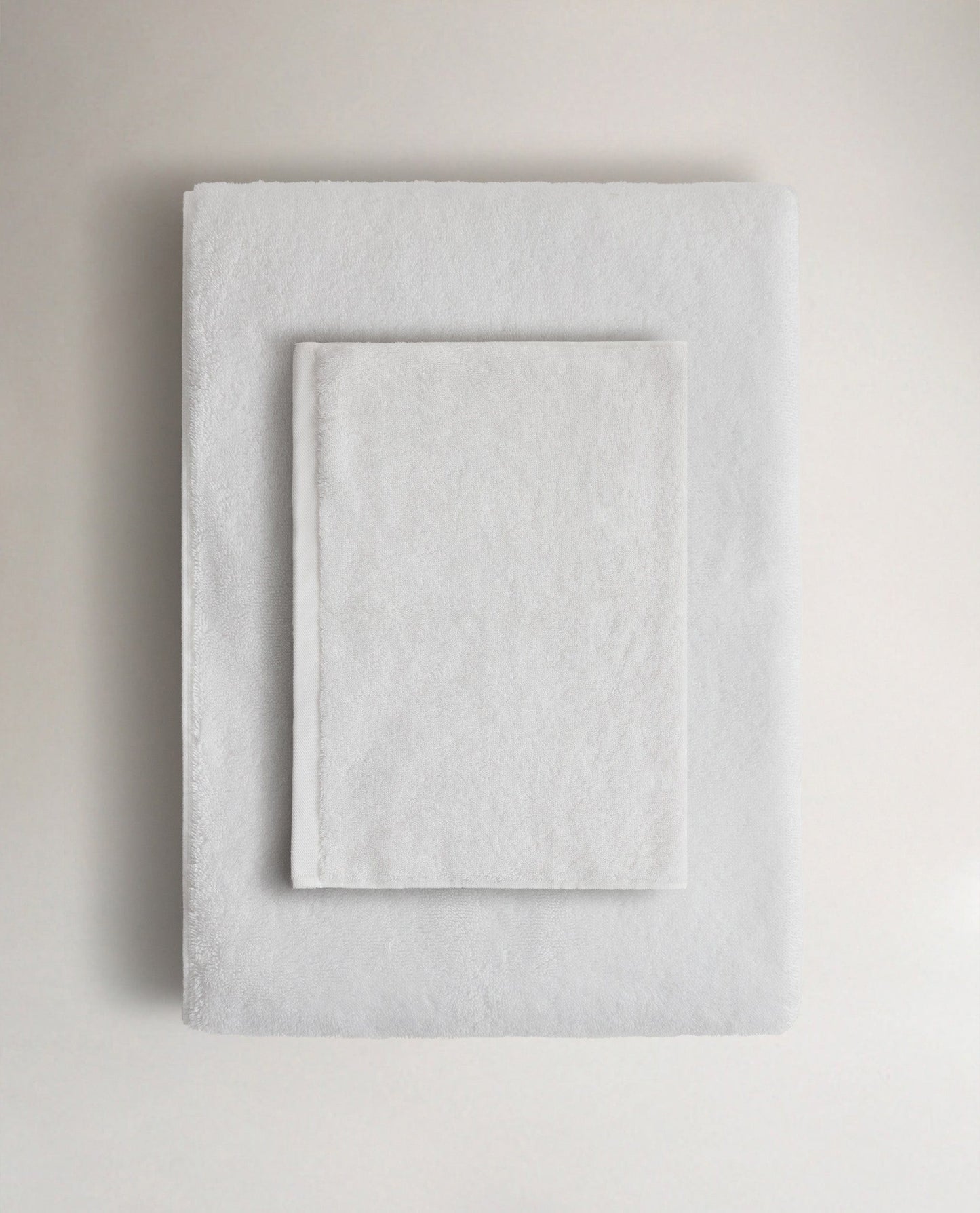 Rise & Fall's white Turkish cotton hand towel lying on top of matching bath towel