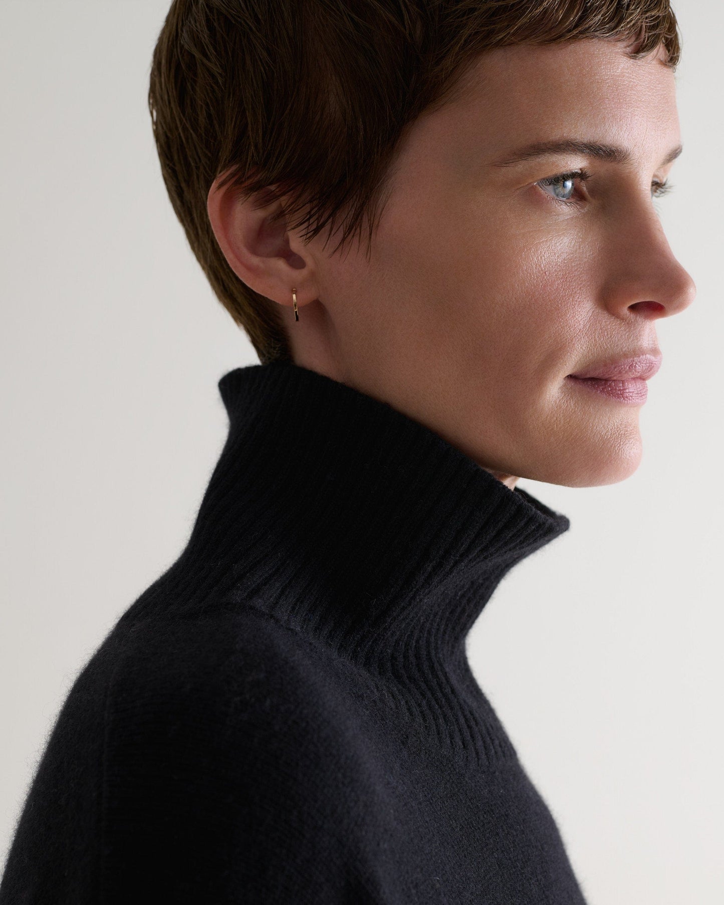 Woman wears black cashmere merimo high neck jumper.