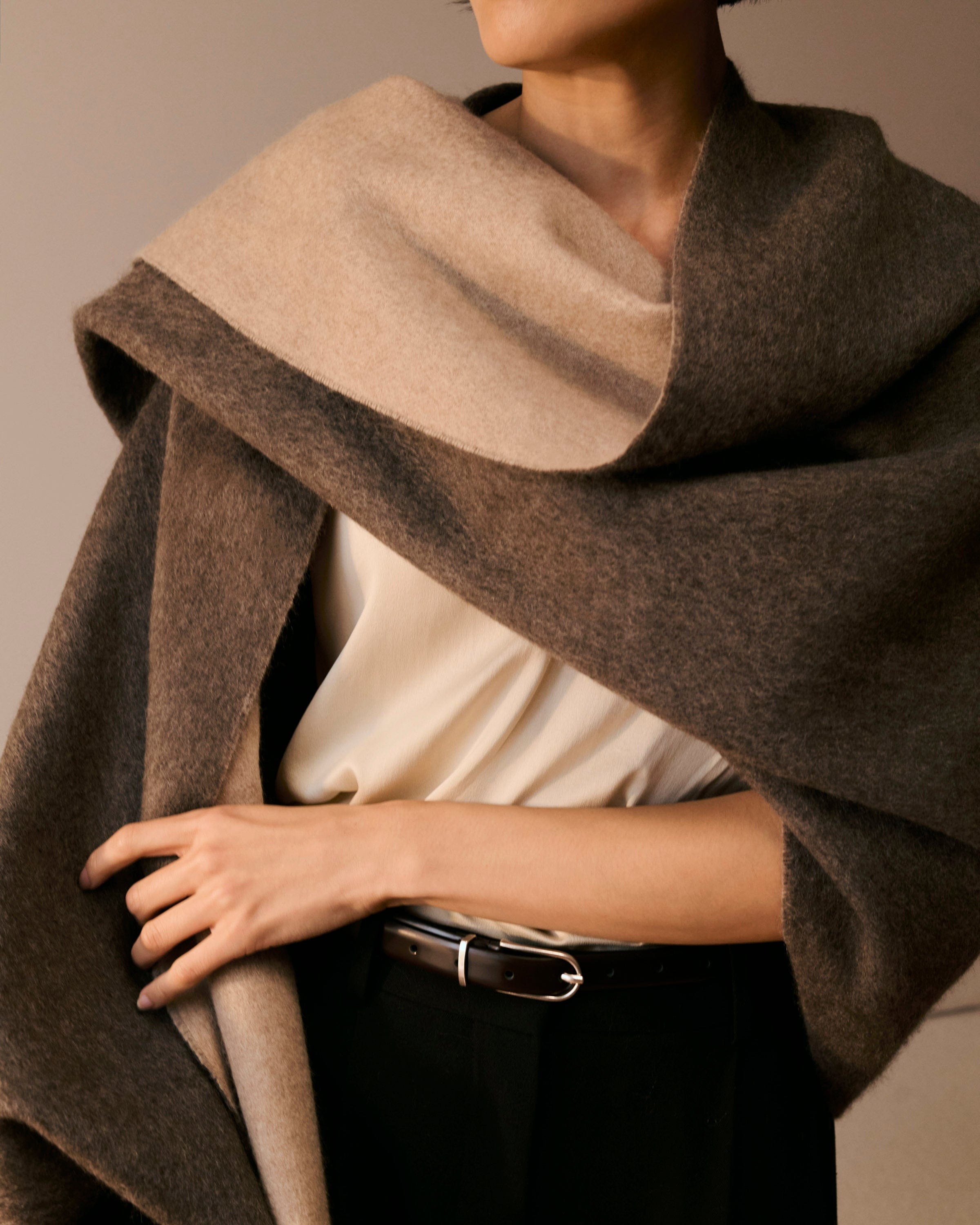 A woman wears a double faced cashmere wrap.