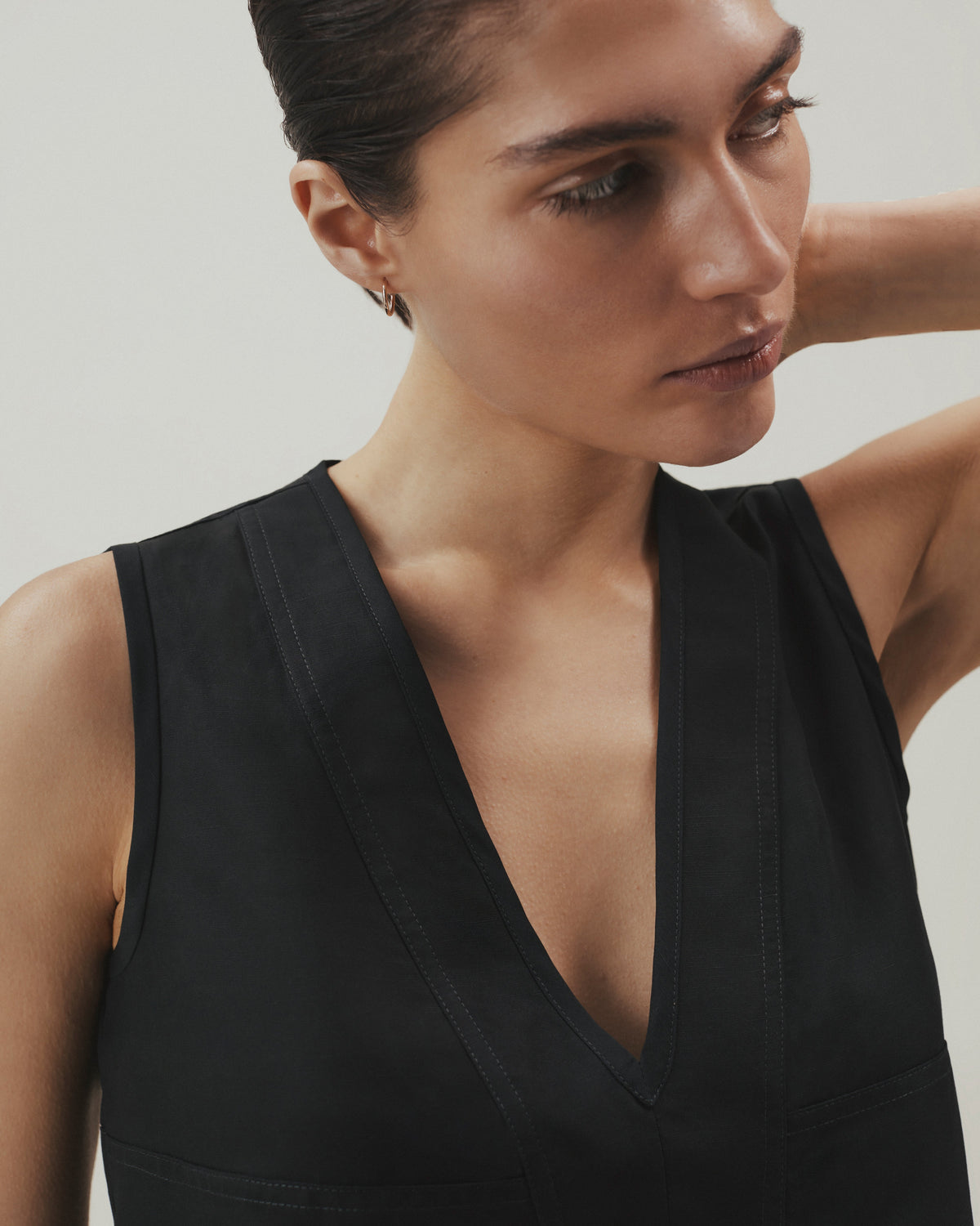 Woman wears Rise & Fall's sleeveless black linen top.