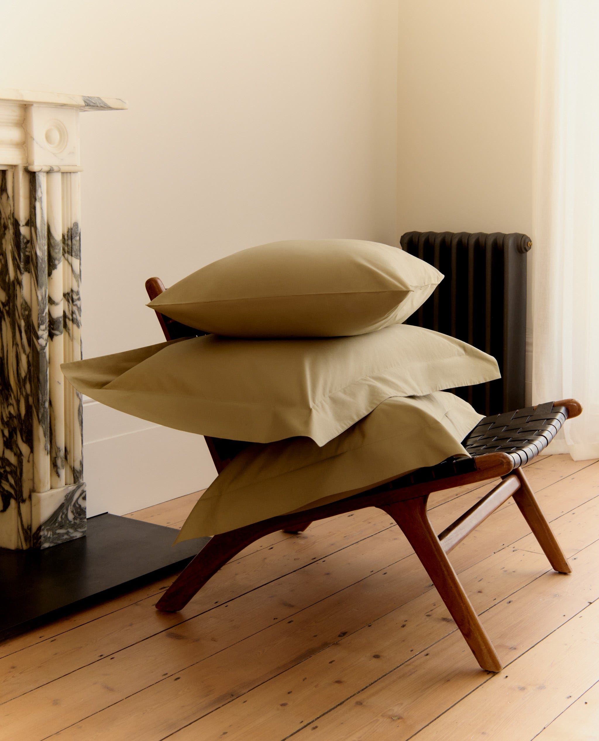 A pile of pillows stacked on a short chair.