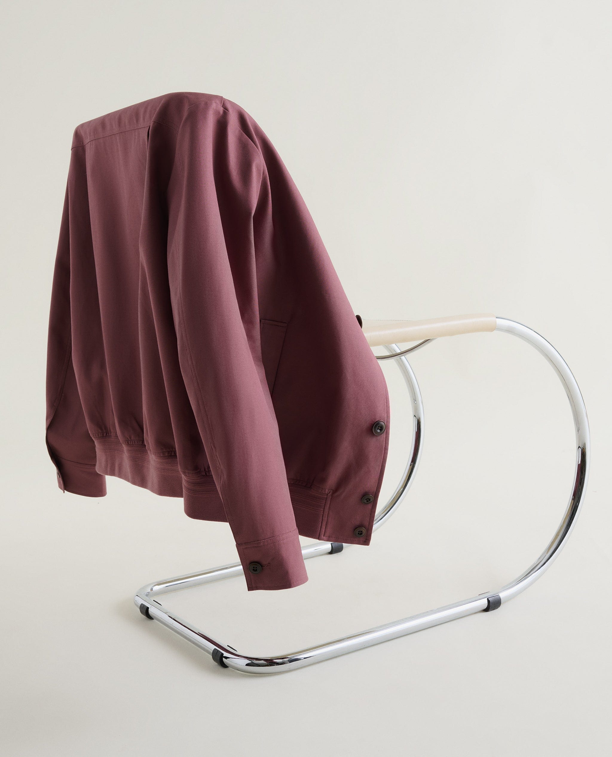 Mauve Linen Jacket Hanging On The Back Of A Chrome Chair