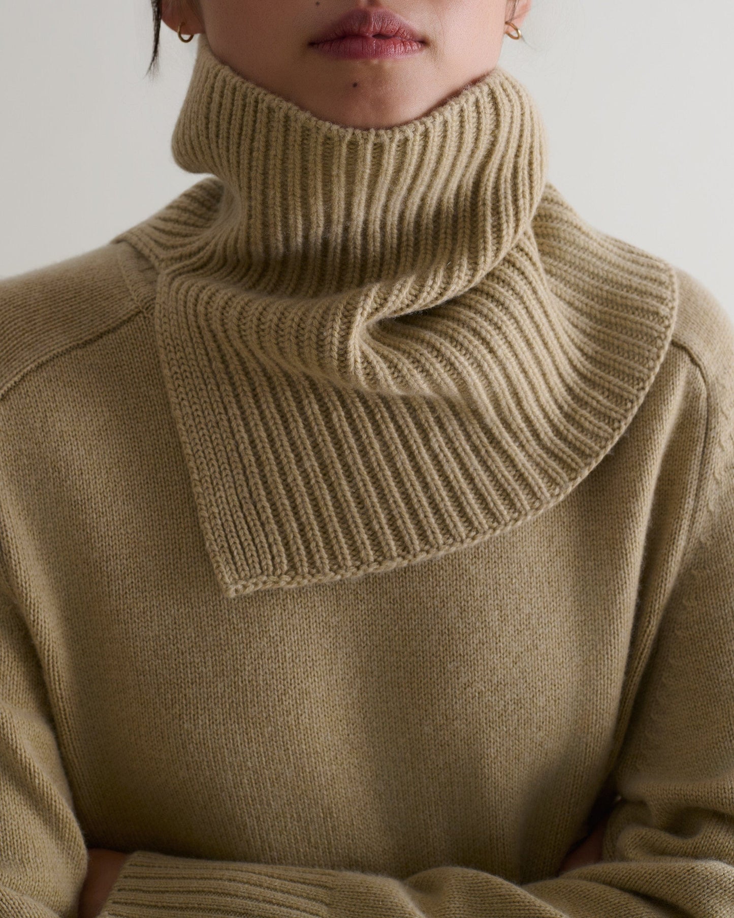 Close-up of a woman wearing twine cashmere merino ribbed collar over a matching jumper