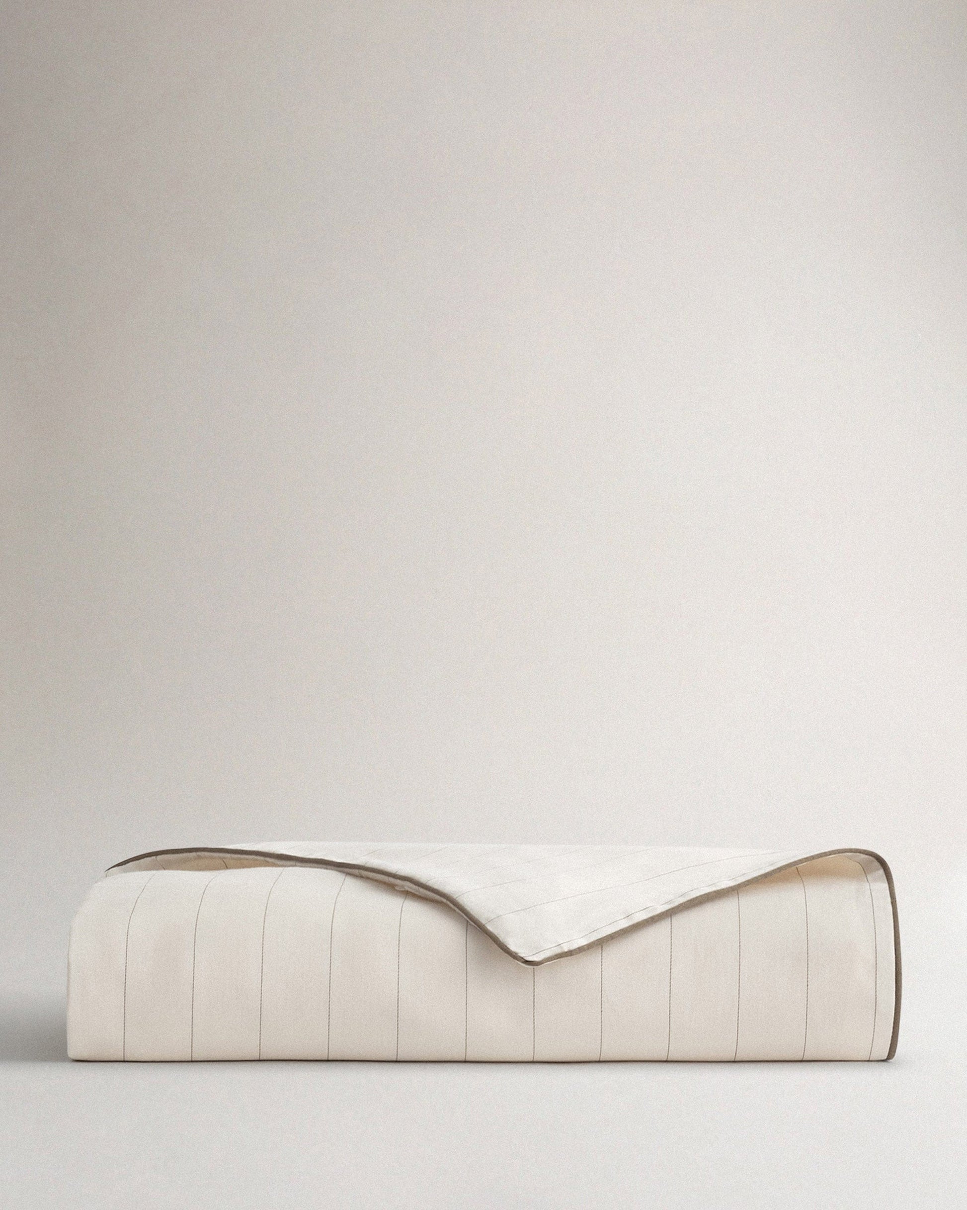 Image 1 of 2 showing Rise & Fall's sateen cotton duvet cover in buttermilk stripe.