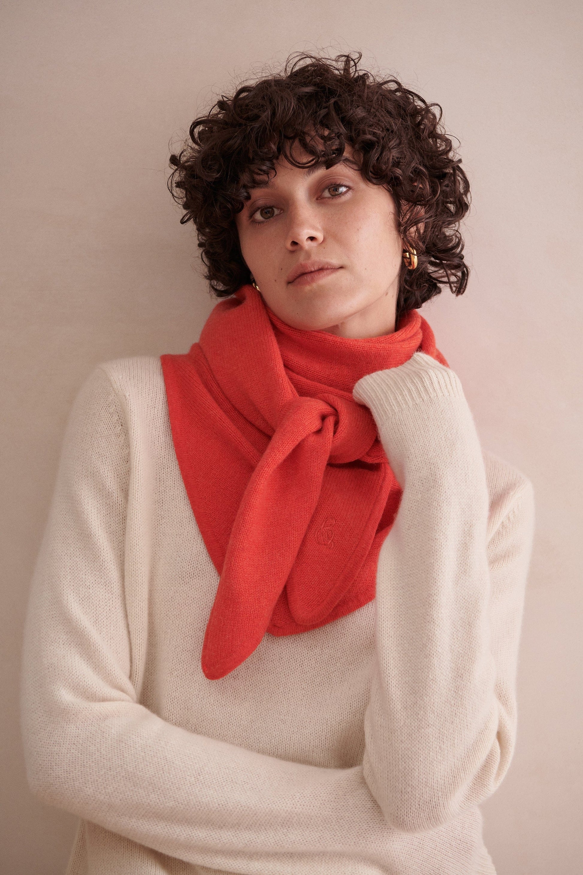 Image 1 of 2 showing woman wearing Rise & Fall's poppy red cashmere merino bandana with cream jumper