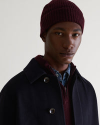 Image 1 of 3 showing man wearing Rise & Fall's Cashmere Merino Ribbed Knit Beanie in oxblood.