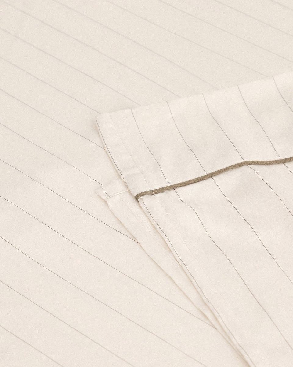 Image 1 of 3 showing Rise & Fall's Soft & Smooth organic sateen cotton flat sheet in buttermilk stripe.