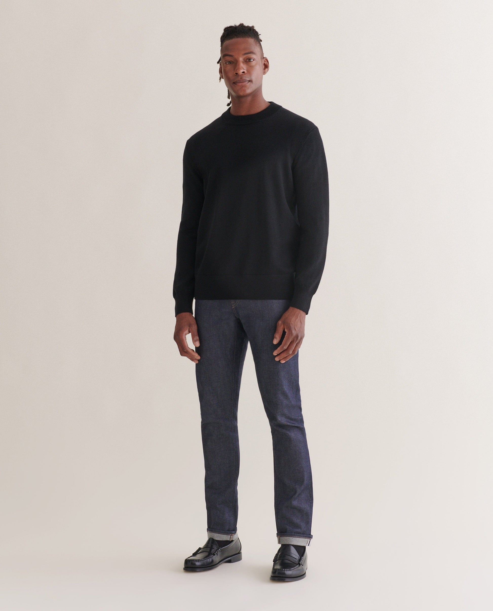 Image 1 of 4 showing man wearing Rise & Fall's merino mid-weight crew neck jumper in black.