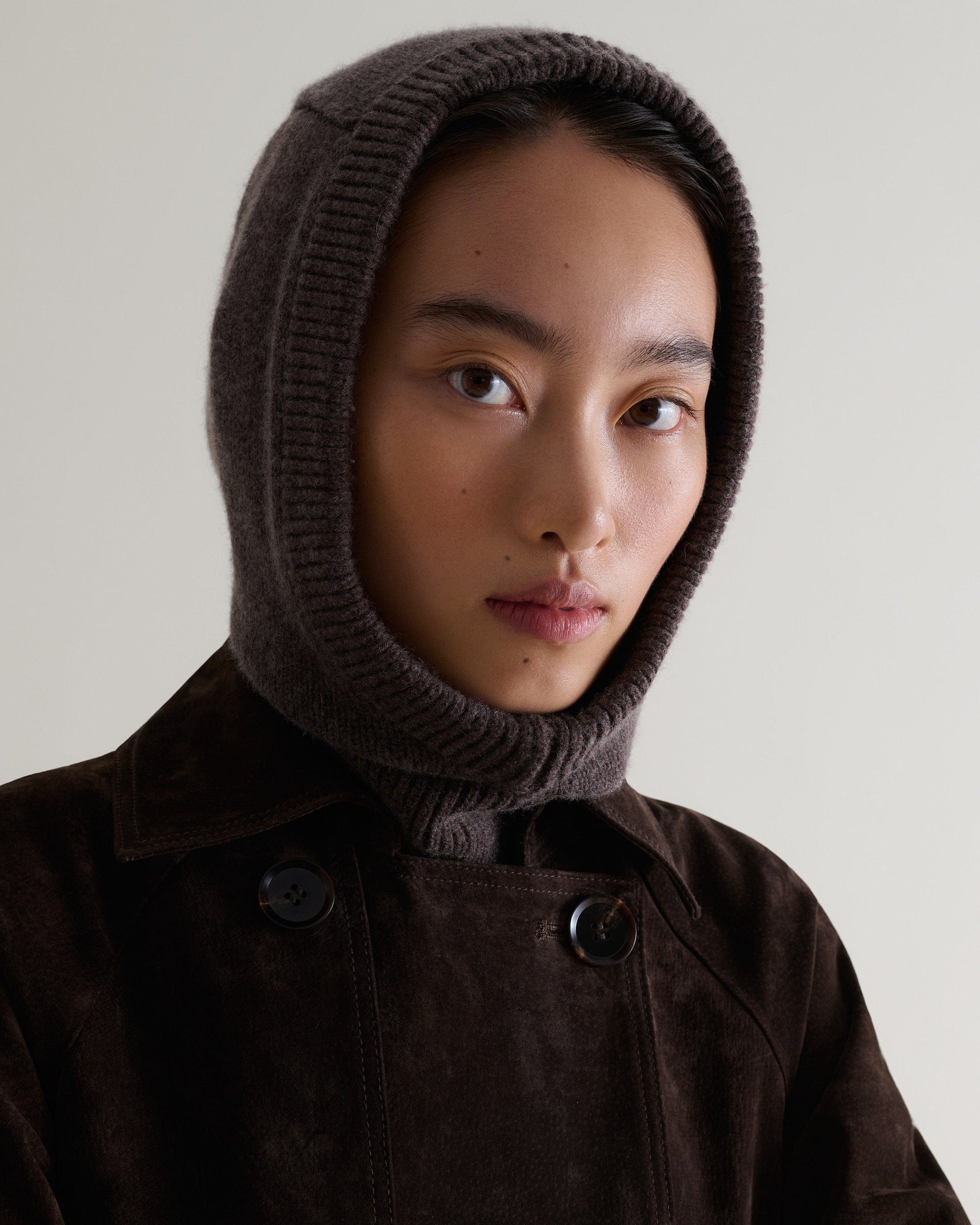 Image 1 of 4 showing woman wearing Rise & Fall's chocolate brown Cashmere Merino Knitted Hood.