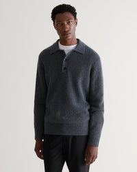 Image 1 of 5 showing man wearing Rise & Fall's graphite cashmere merino fisherman ribbed polo jumper with white T-Shirt and black trousers