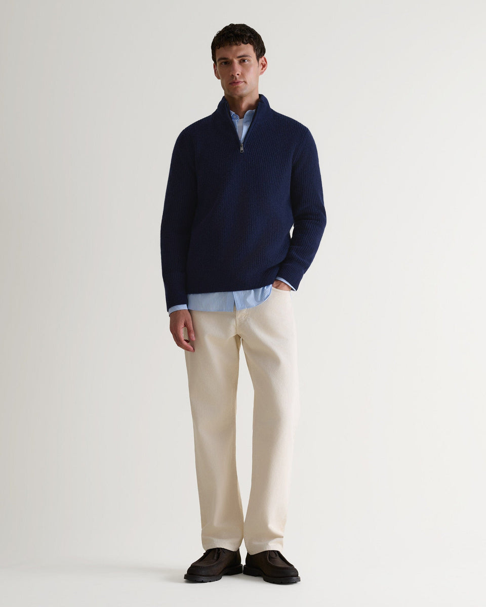 Image 1 of 5 showing man wearing Rise & Fall's Cashmere Merino Fishermans Rib 1/4 Zip Jumper in navy.