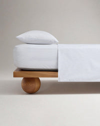 Image 1 of 5 showing Rise & Fall's Crisp & Cool organic percale cotton flat bed sheet in blue ticking stripe.