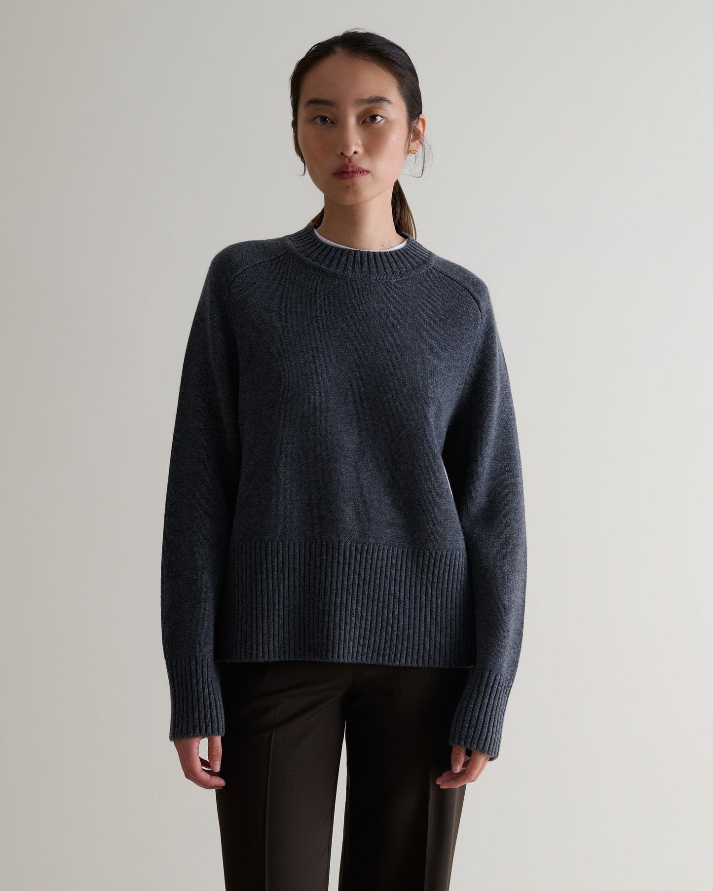 Image 1 of 5 showing woman wearing Rise & Fall cashmere merino saddle sleeve crew neck jumper, colour: graphite.