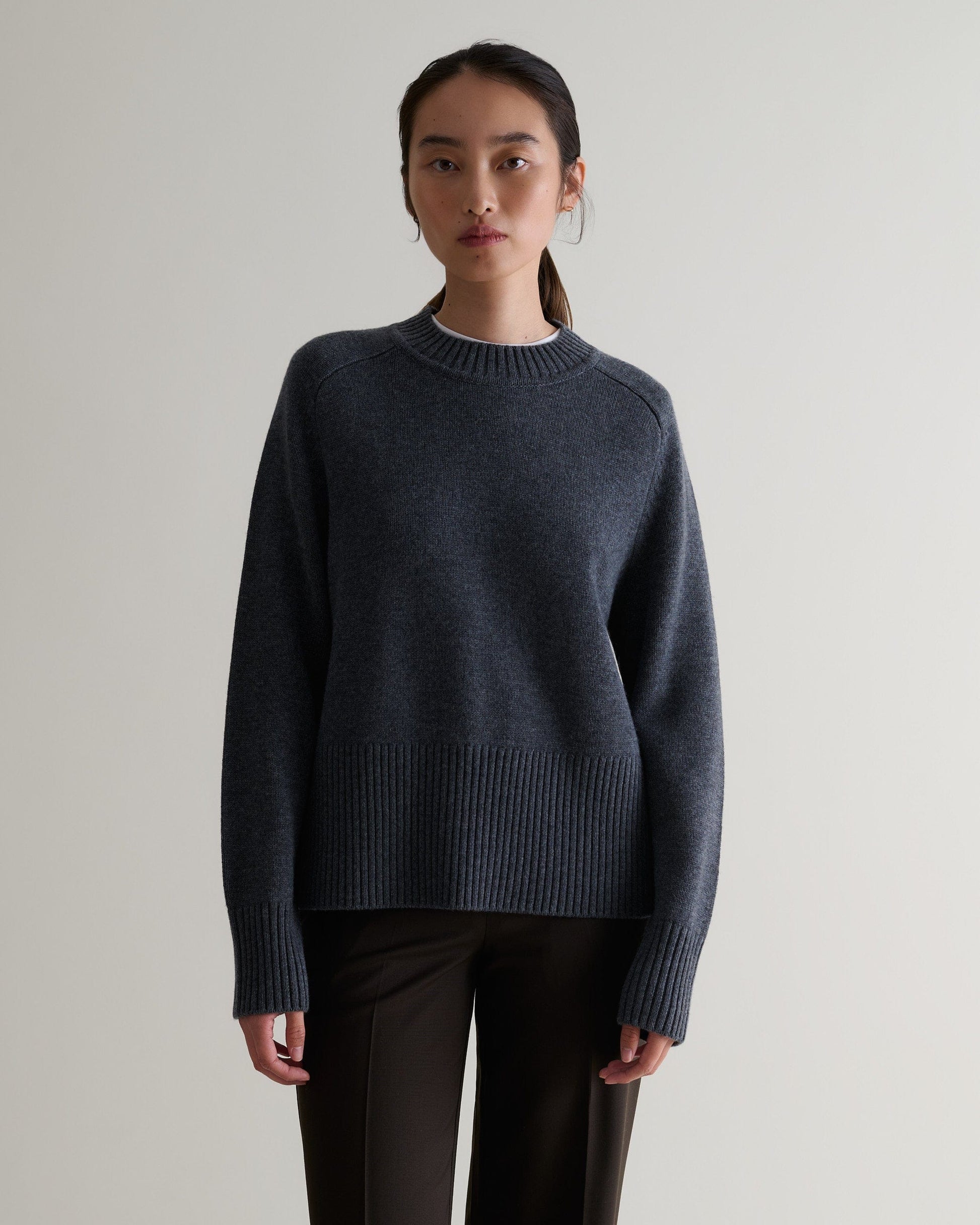 Image 1 of 5 showing woman wearing Rise & Fall cashmere merino saddle sleeve crew neck jumper, colour: graphite.
