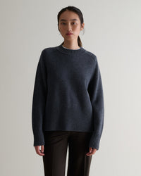 Image 1 of 5 showing woman wearing Rise & Fall cashmere merino saddle sleeve crew neck jumper, colour: graphite.