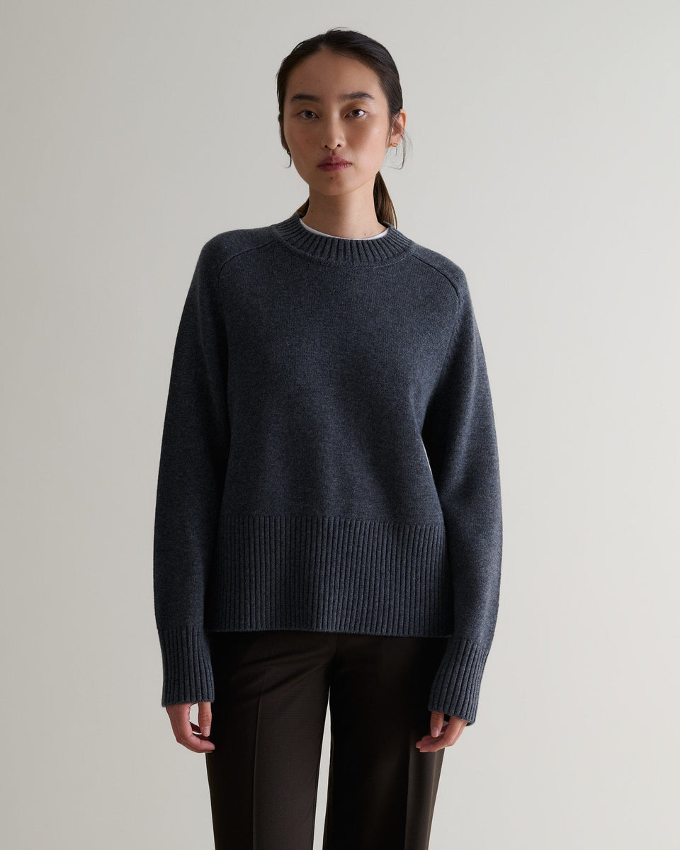 Image 1 of 5 showing woman wearing Rise & Fall cashmere merino saddle sleeve crew neck jumper, colour: graphite.