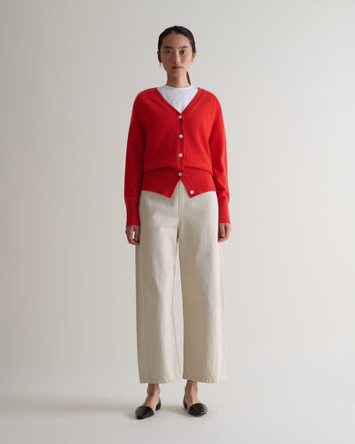 Image 1 of 5 showing Rise & Fall's poppy red fine cashmere blouson cardigan with white T-shirt and cream trousers.