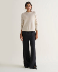 Image 1 of 5 showing woman wearing Rise & Fall's cream mid-weight cashmere crew neck jumper with black trousers.
