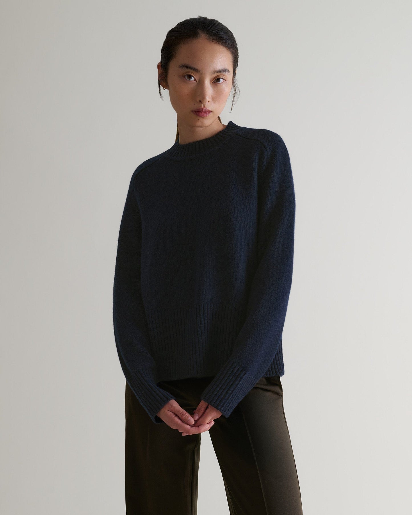 Image 1 of 6 showing woman wearing Rise & Fall cashmere merino saddle sleeve crew neck jumper, colour: indigo.