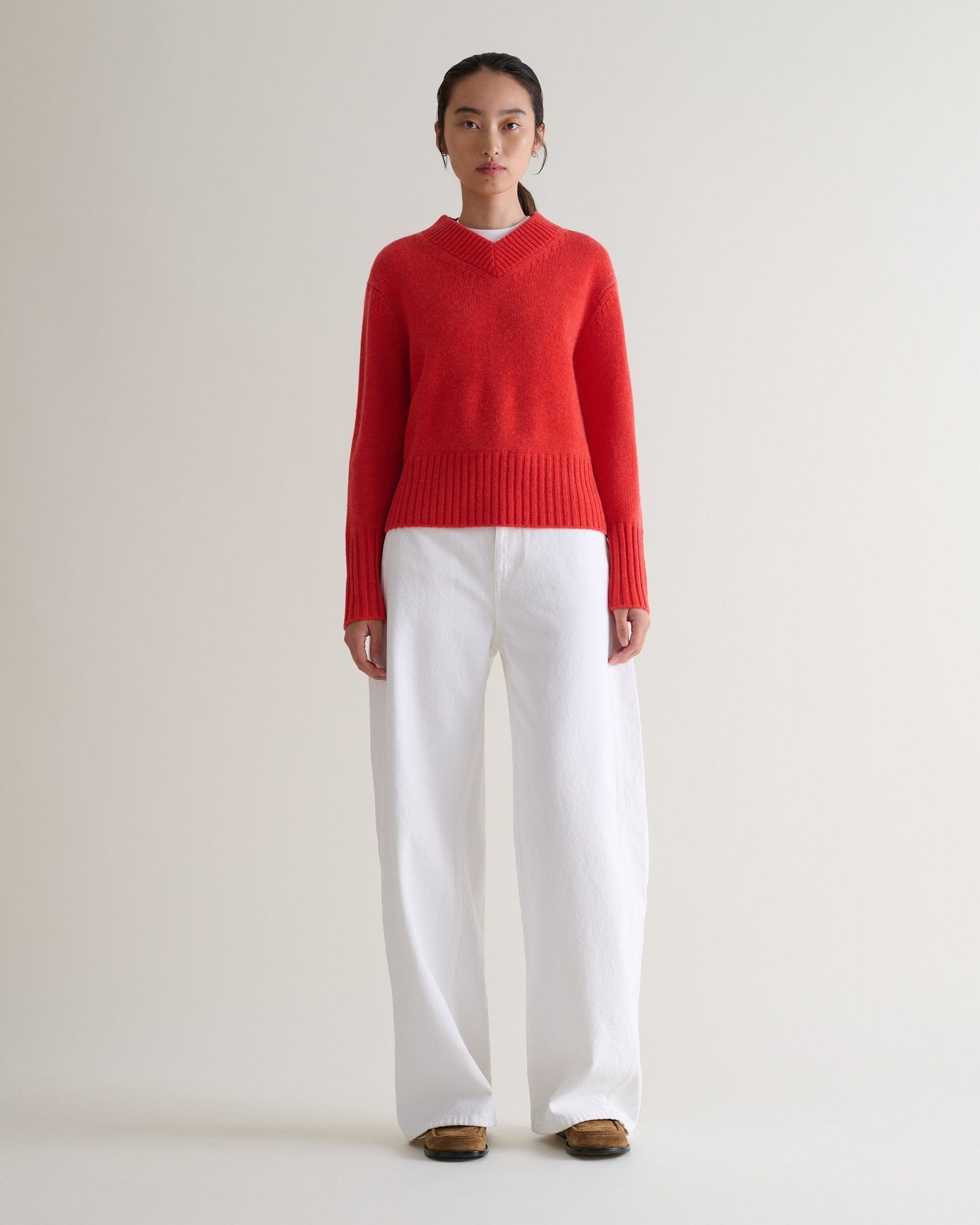 Image 1 of 6 showing woman wearing Rise & Fall cashmere merino saddle sleeve crew neck jumper, colour: poppy red.