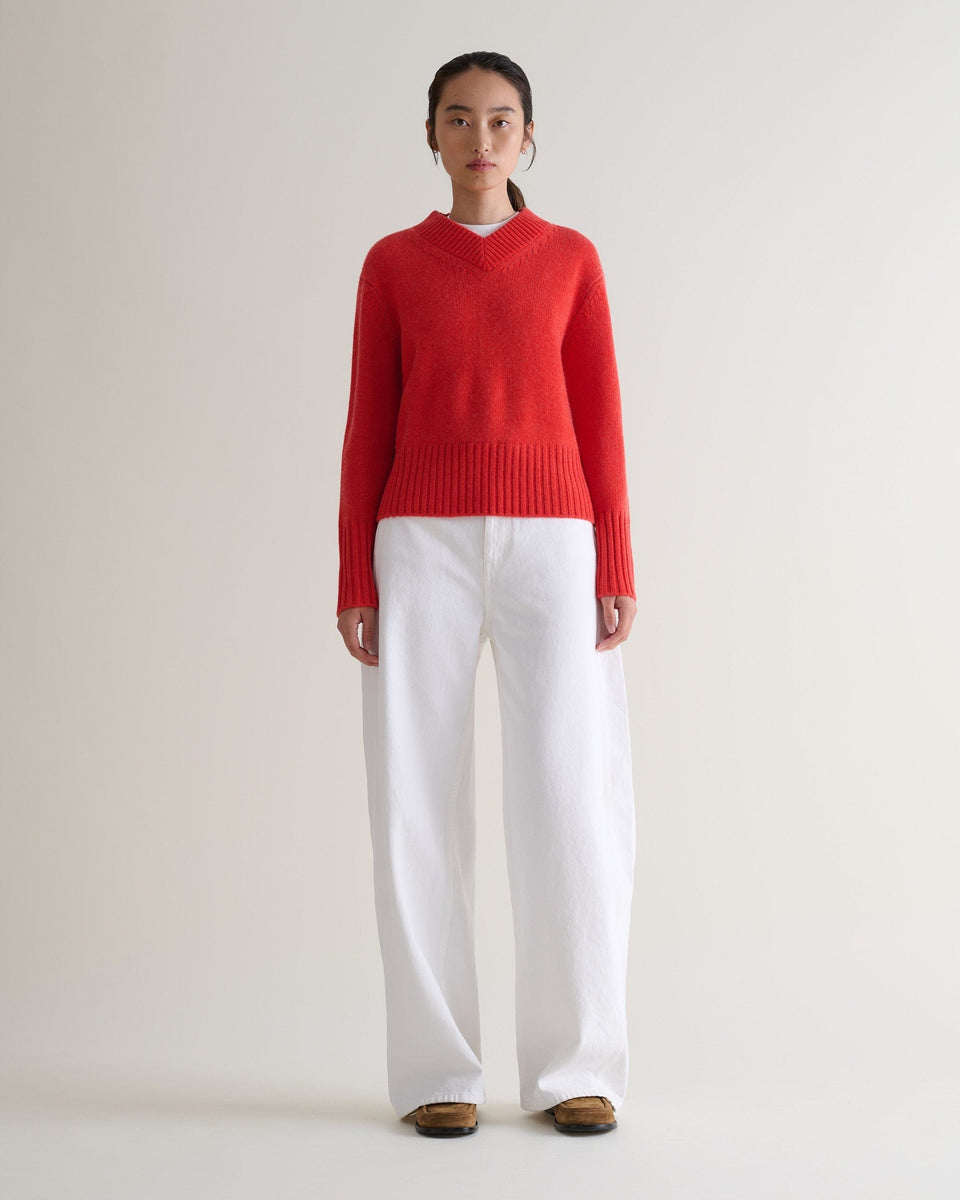 Image 1 of 6 showing woman wearing Rise & Fall cashmere merino saddle sleeve crew neck jumper, colour: poppy red.