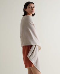 Image 1 of 6 showing woman wrapping Rise & Fall's oversized cashmere scarf around shoulders, colour: light beige.