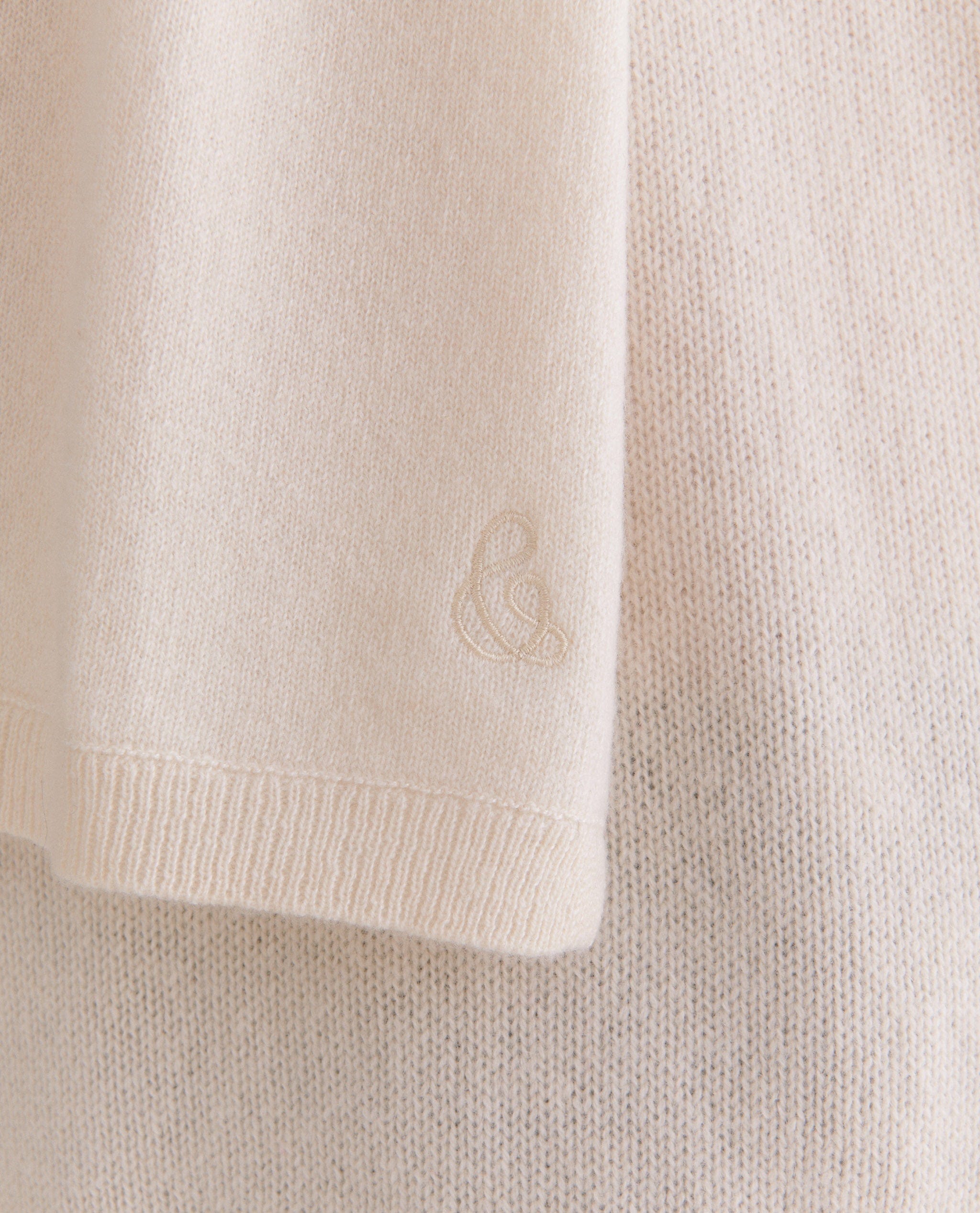 Image 2 of 2 showing close up of Rise & Fall's women's finest cashmere scarf in buttermilk cream with logo embelleshment. 