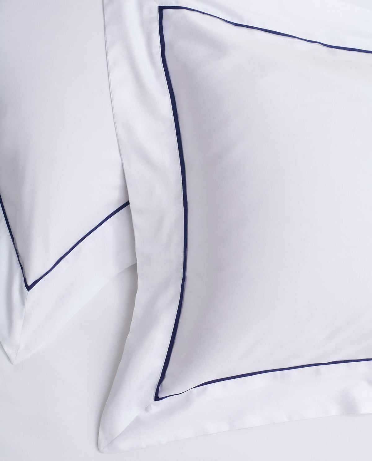 Image 2 of 4 showing Rise & Fall's Soft & Smooth Cotton Sateen Oxford Pillowcase Set in white navy piping.